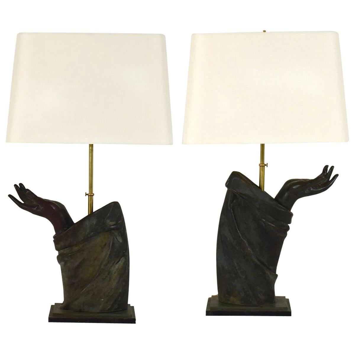 A sculptural pair of French bronze arm lamps with linen shades.