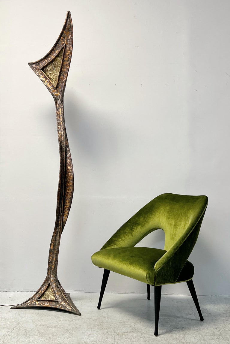 A pair of sculptural floor lamps. Modern fluid lines bordering on abstraction with a definite organic flavor. Done in a melted metal on metal technique.