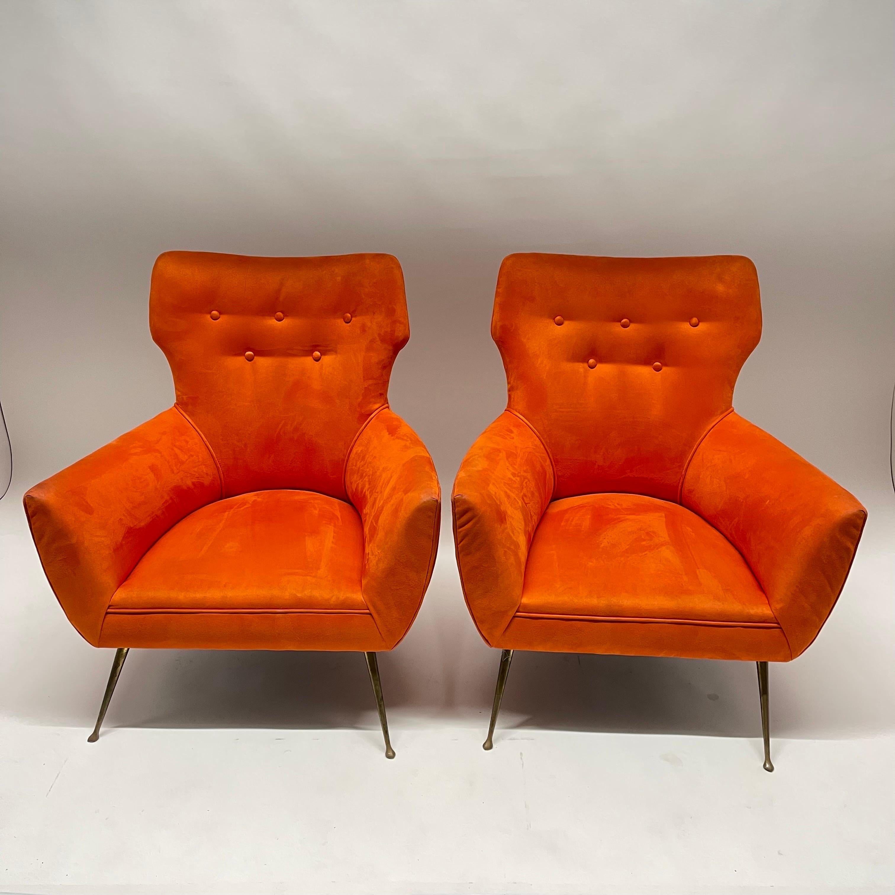 Pair of sculptural Italian midcentury arm club or lounge chairs, rendered in orange ultra suede with splayed brass legs, ISA, Italy, circa 1950s.