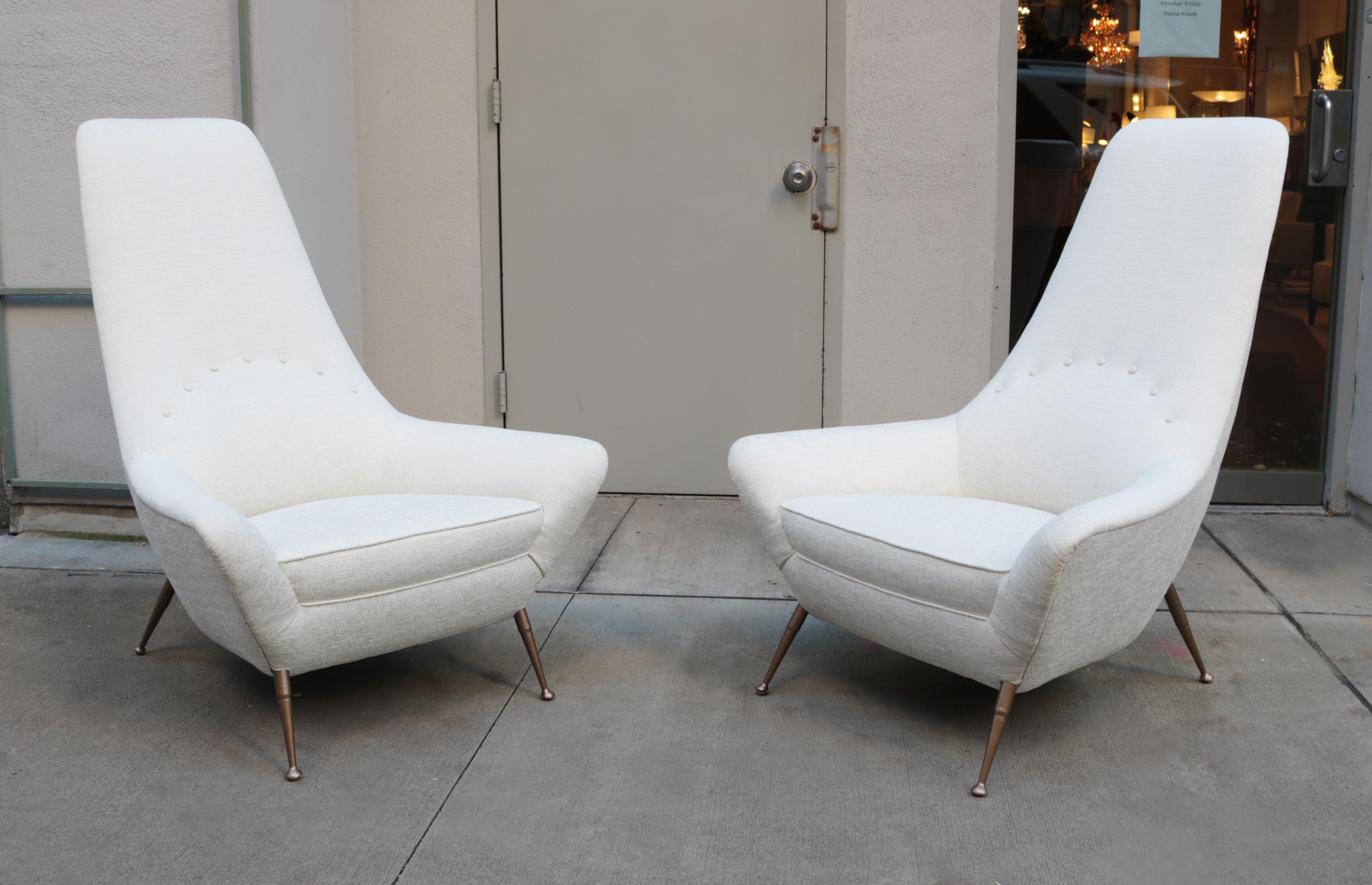 Pair of stylish sculptural tall back Italian Modernist lounge chairs. 
Newly upholstered with brass leg details.