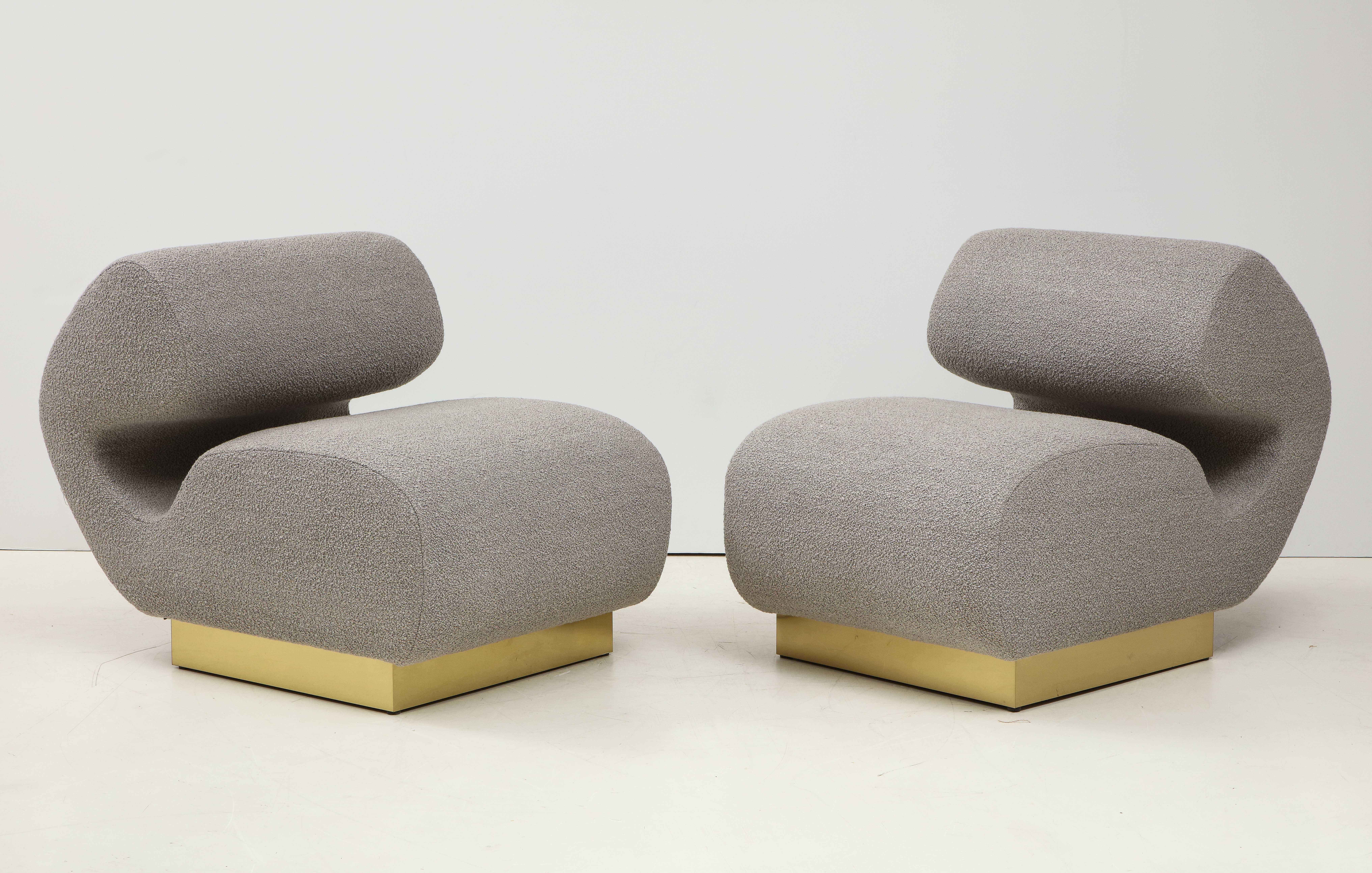 Pair of grey bouclé sculptural lounge or slipper chairs custom made in Florence, Italy by a master furniture artisan. Superb craftsmanship and design lines. These large and roomy lounge chairs are extremely comfortable and sit atop a square brass