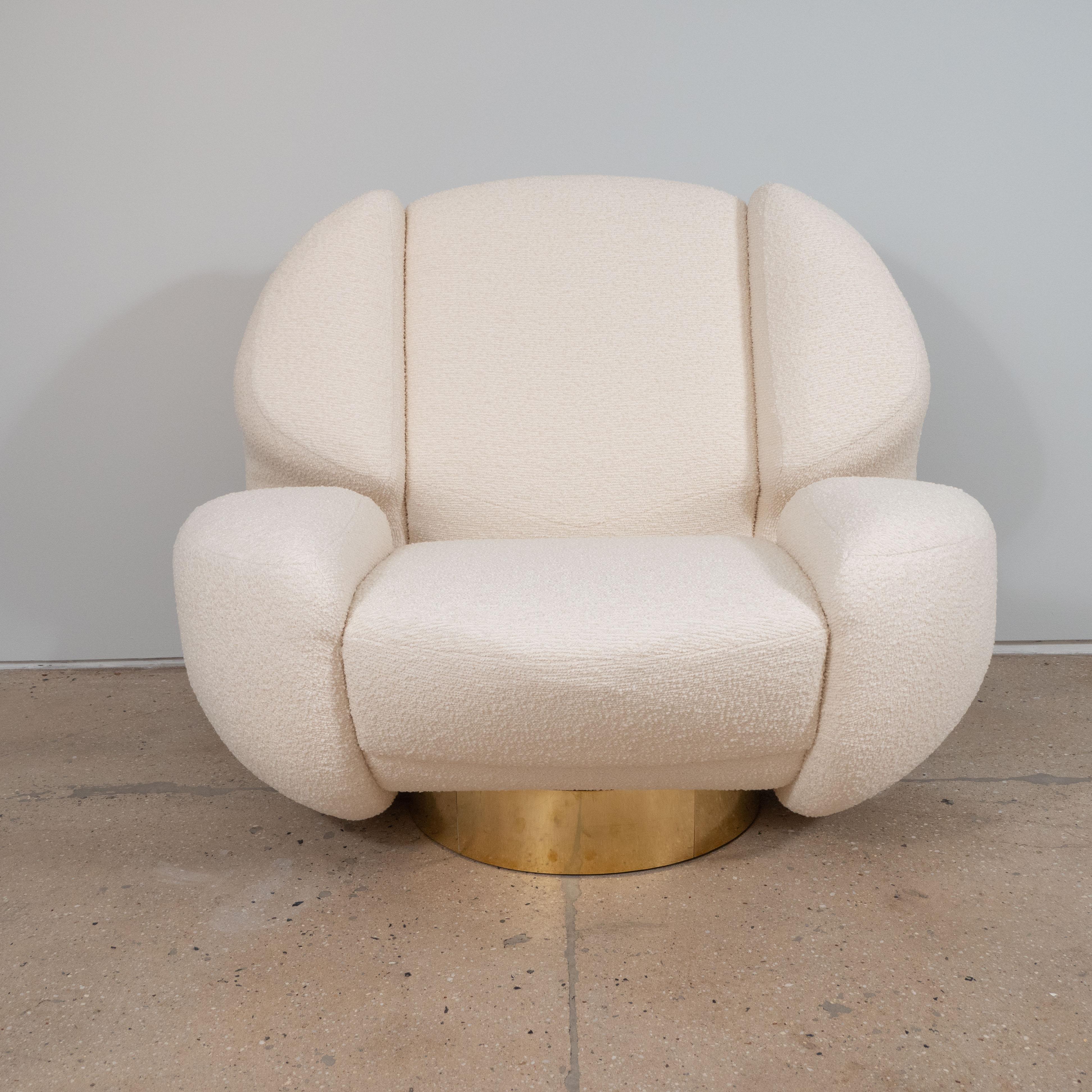 Pair of ivory bouclé and brass sculptural lounge chairs in the style of 