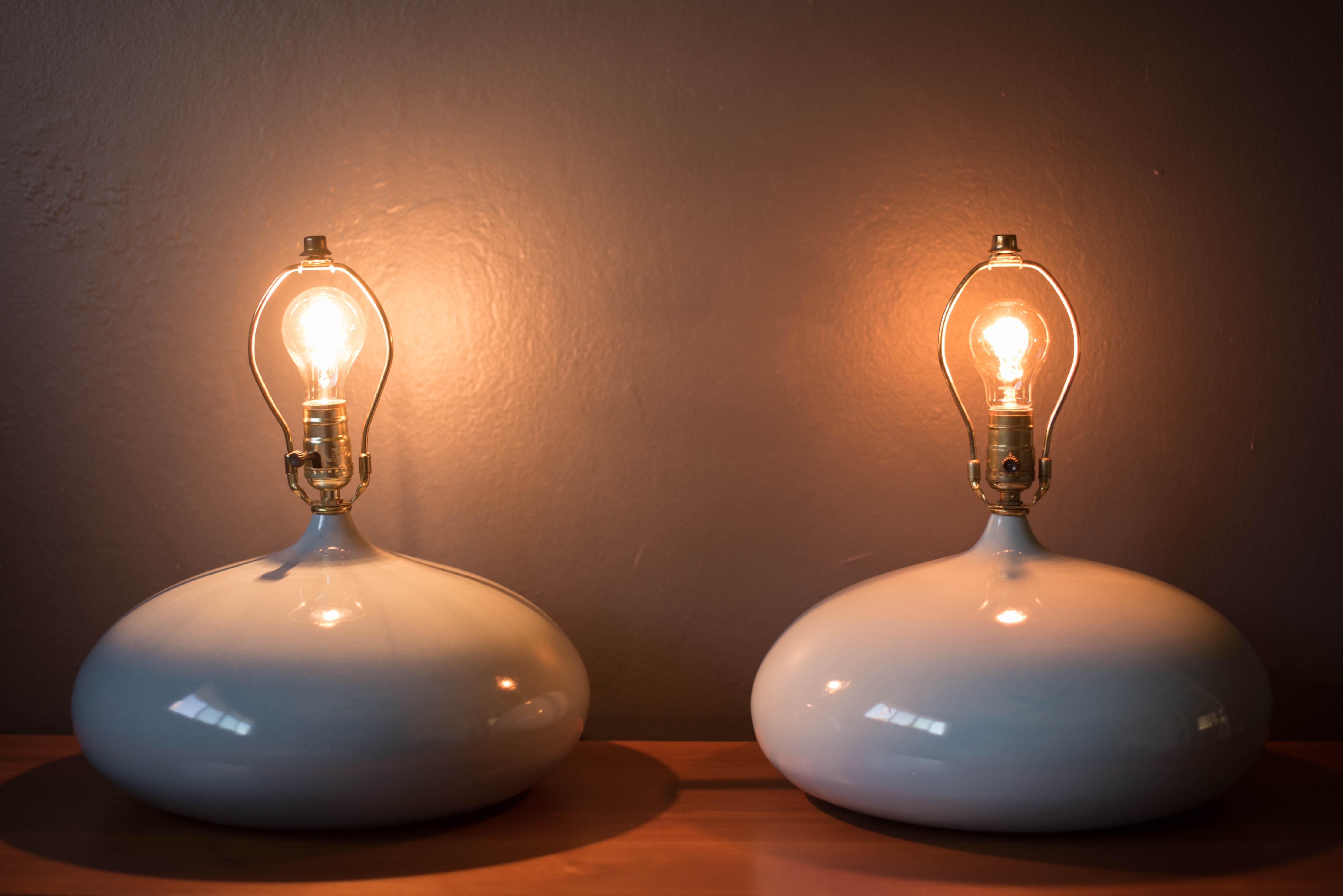 Vintage pair of sculptural ceramic table lamps, circa 1960s. Features a unique round base in a light gray glossy finish. Perfect to add to any contemporary decor or modern space. Includes a three-way switch. Price is for the pair.
    
