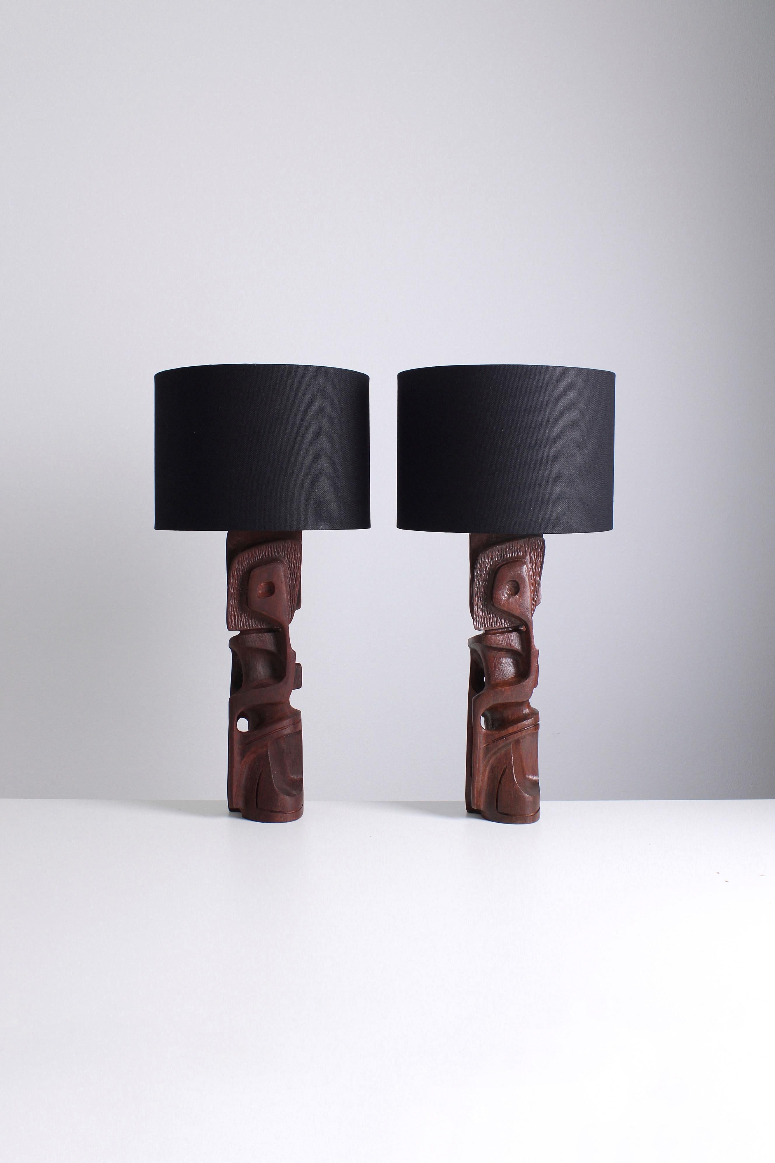 Eine Reihe von skulpturalen Tischlampen, die Gianni Pinna in den 1970er Jahren entworfen hat. Die aus Legno Padouk-Holz gefertigten Lampen strahlen eine robuste und brutalistische Ästhetik aus. Es ist erwähnenswert, dass beide Lampen zwar ein