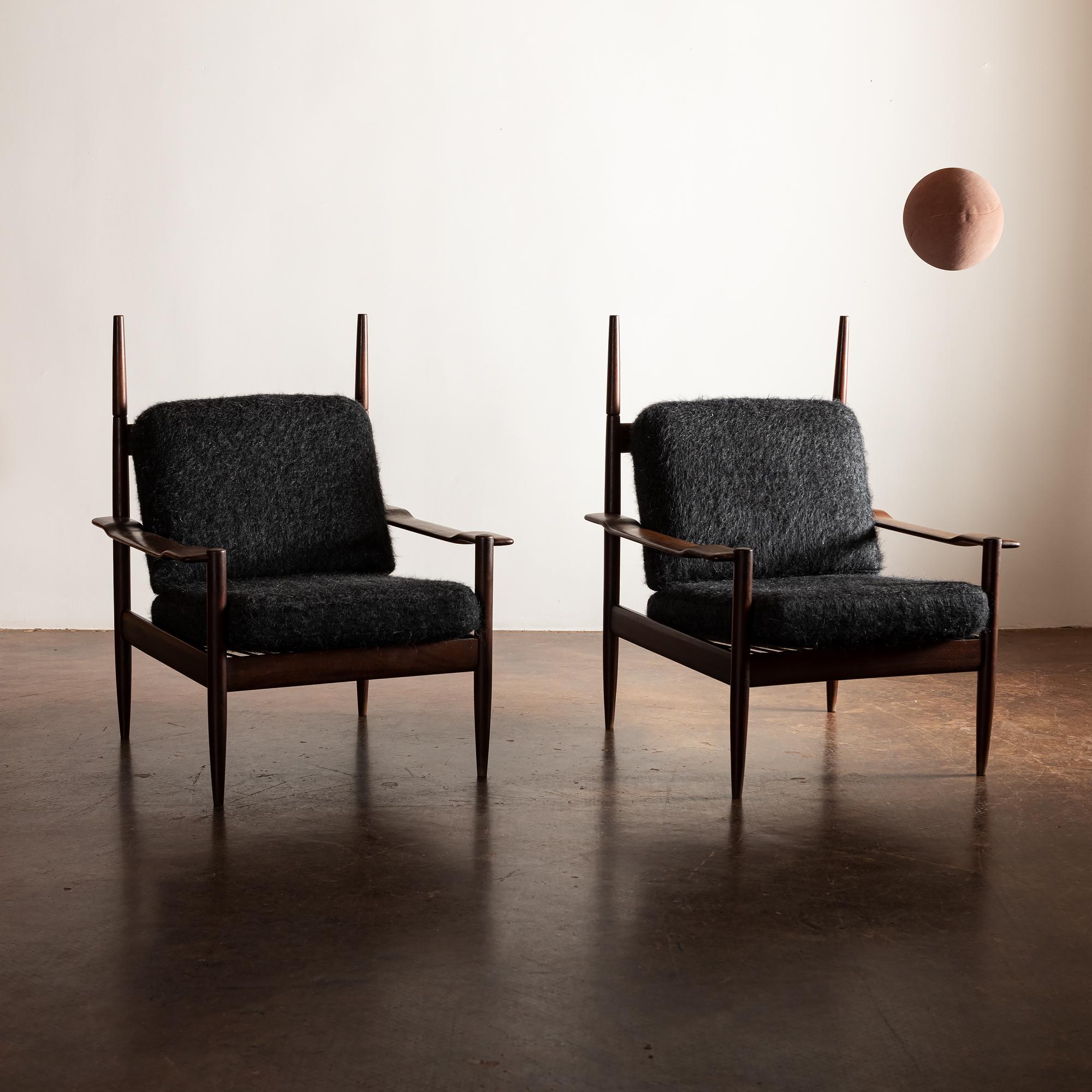 A sculptural pair of teak chairs with shaped arms and extended finials on the back. Stately and dramatic. Recently reupholstered in Pierre Frey Yeti Bagheera. Brazil, 1960s.