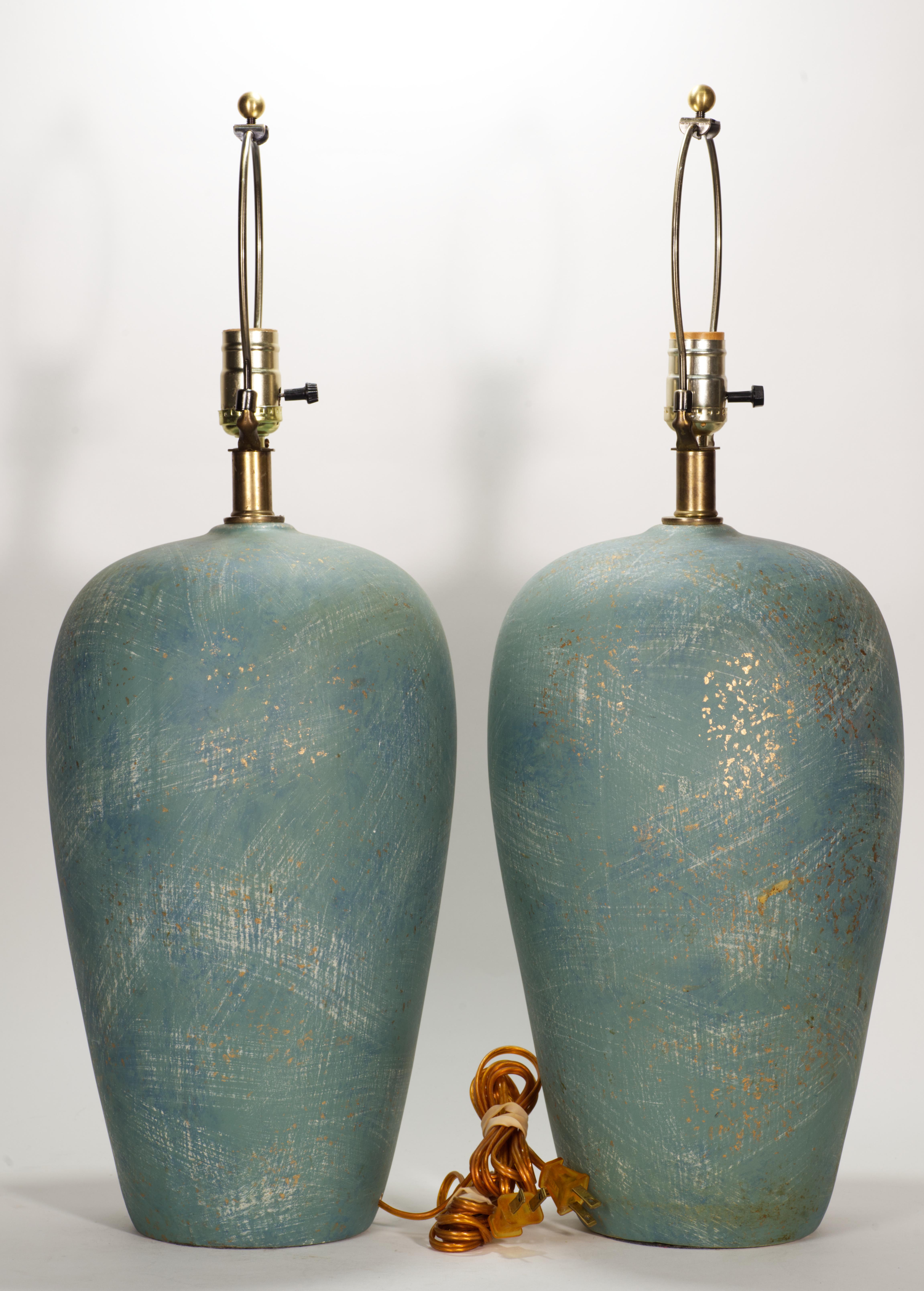 Pareja de grandes y esculturales lámparas de cerámica con cuello de latón, de complejo esmalte semimate en azul cerceta y gris paloma claro; unos discretos toques metálicos dorados, distribuidos aleatoriamente por el esmalte, añaden textura e