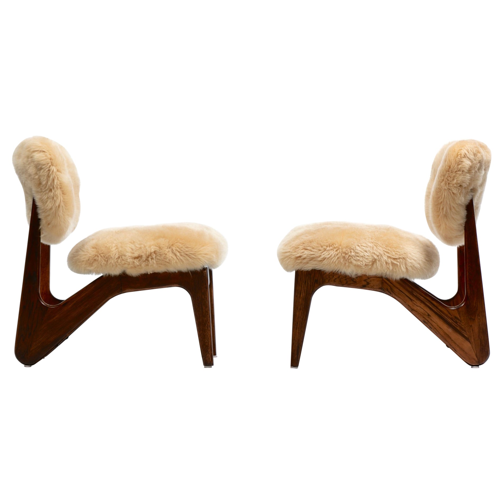 Paire de chaises pantoufles sculpturales en noyer avec des peaux de mouton neuves de couleur crème caramel en vente