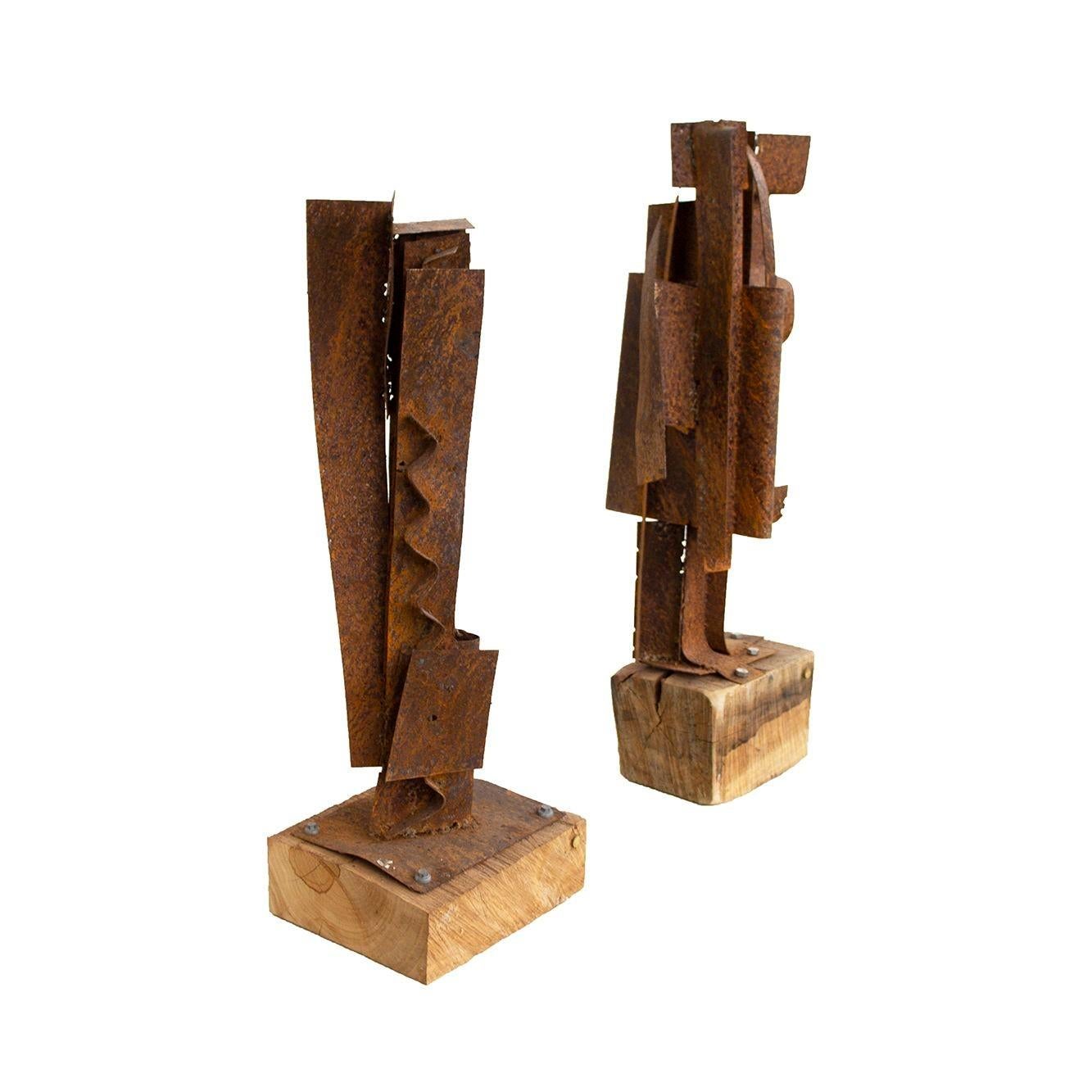 Pair of handmade sculptures by American artist PKW. Rusted steel mounted into a solid fallen wood base. Signed on bases. As a pair they are a great mismatched pair with excellent scale for display. 
DIMENSIONS
Sculpture 1 (larger)- base measures