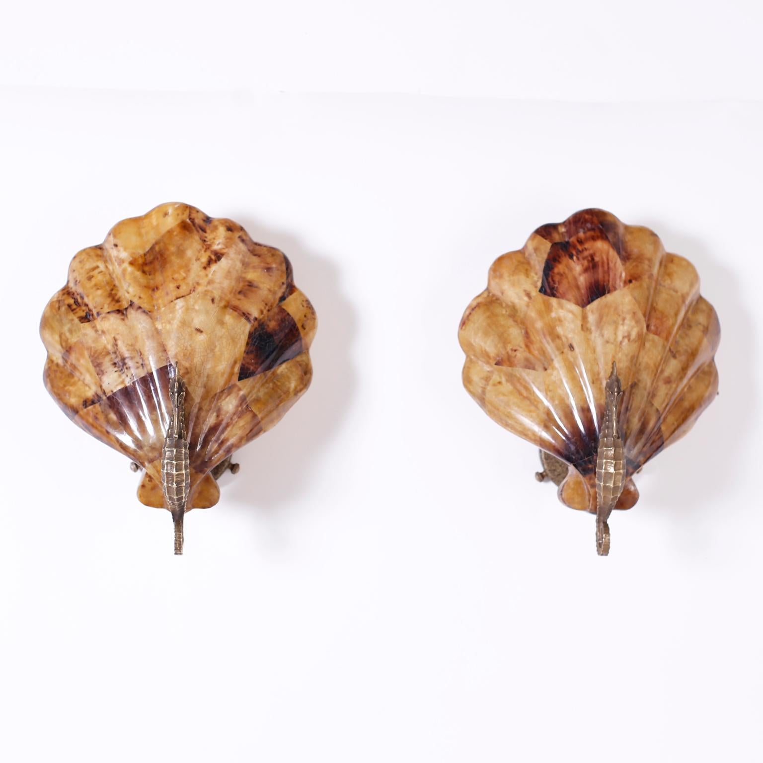 Pair of wall sconces with cast brass seahorses in front of seashell form shades crafted in penshell by Maitland Smith.
