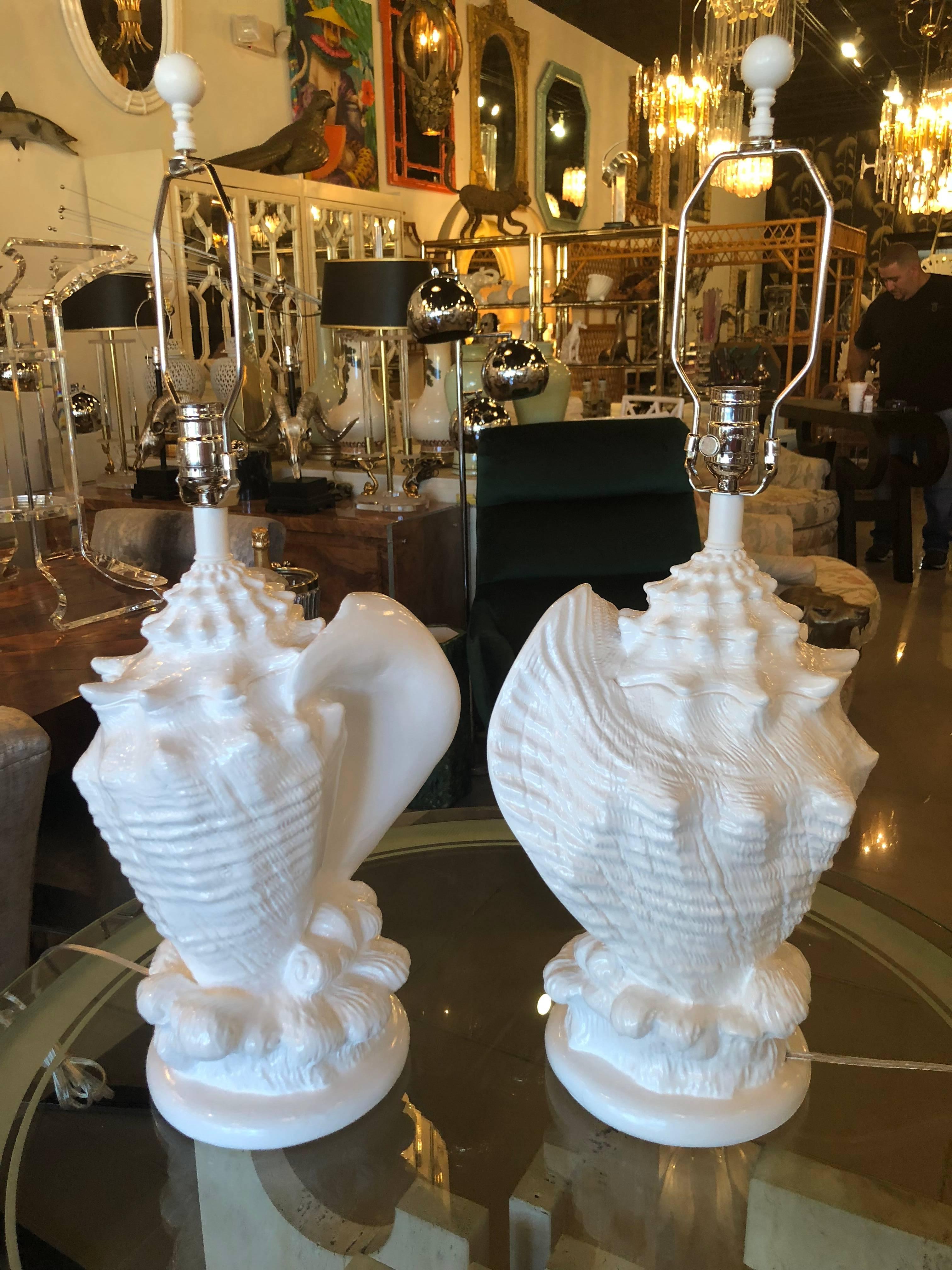 Vintage pair of white lacquered plaster shell seashell table lamps. These have been newly restored. Newly rewired, new chrome sockets and harps. Matching finials included.
Measure: Height to top of finial is 28.5. Height to top of socket is 20.