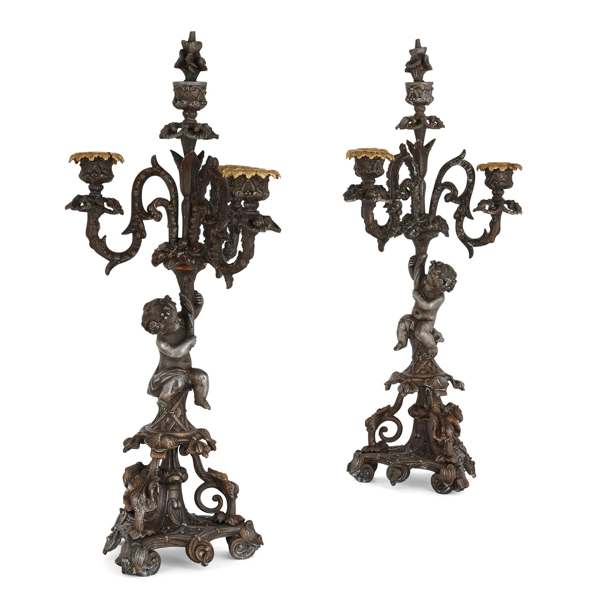 Pair of Second Empire period candelabra
French, circa 1860
Measures: Height 52cm, width 23cm, depth 16cm

Each candelabrum in this pair, wrought in the charming Second Empire style from patinated metal, features a central shaped column raised