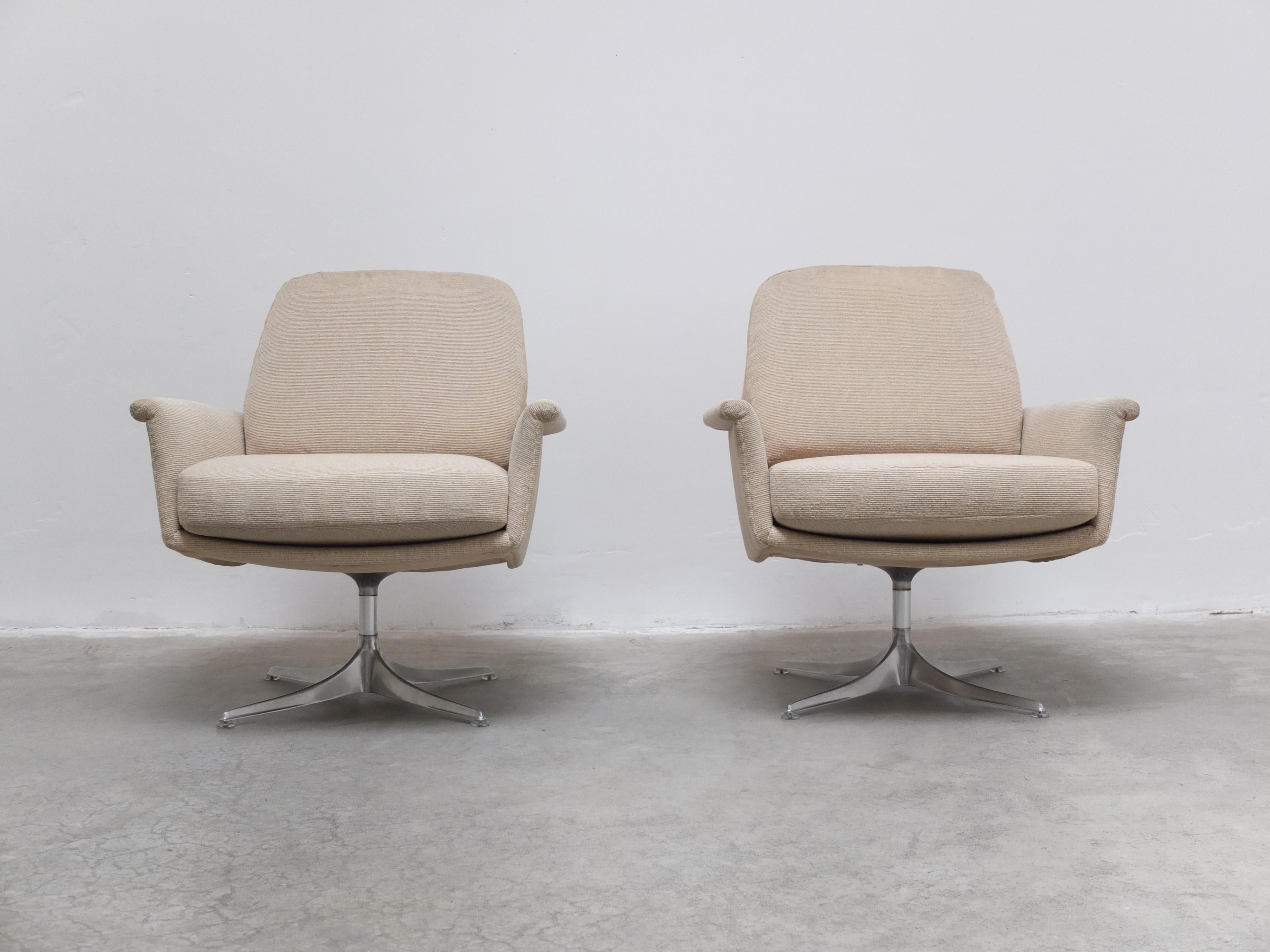 Lovely pair of 'Sedia' swivel lounge chairs designed by Horst Brüning for COR around 1960. The beautiful aluminum base with swivel function gives these chairs a modern and timeless appearance. This set comes with the original beige fabric in very