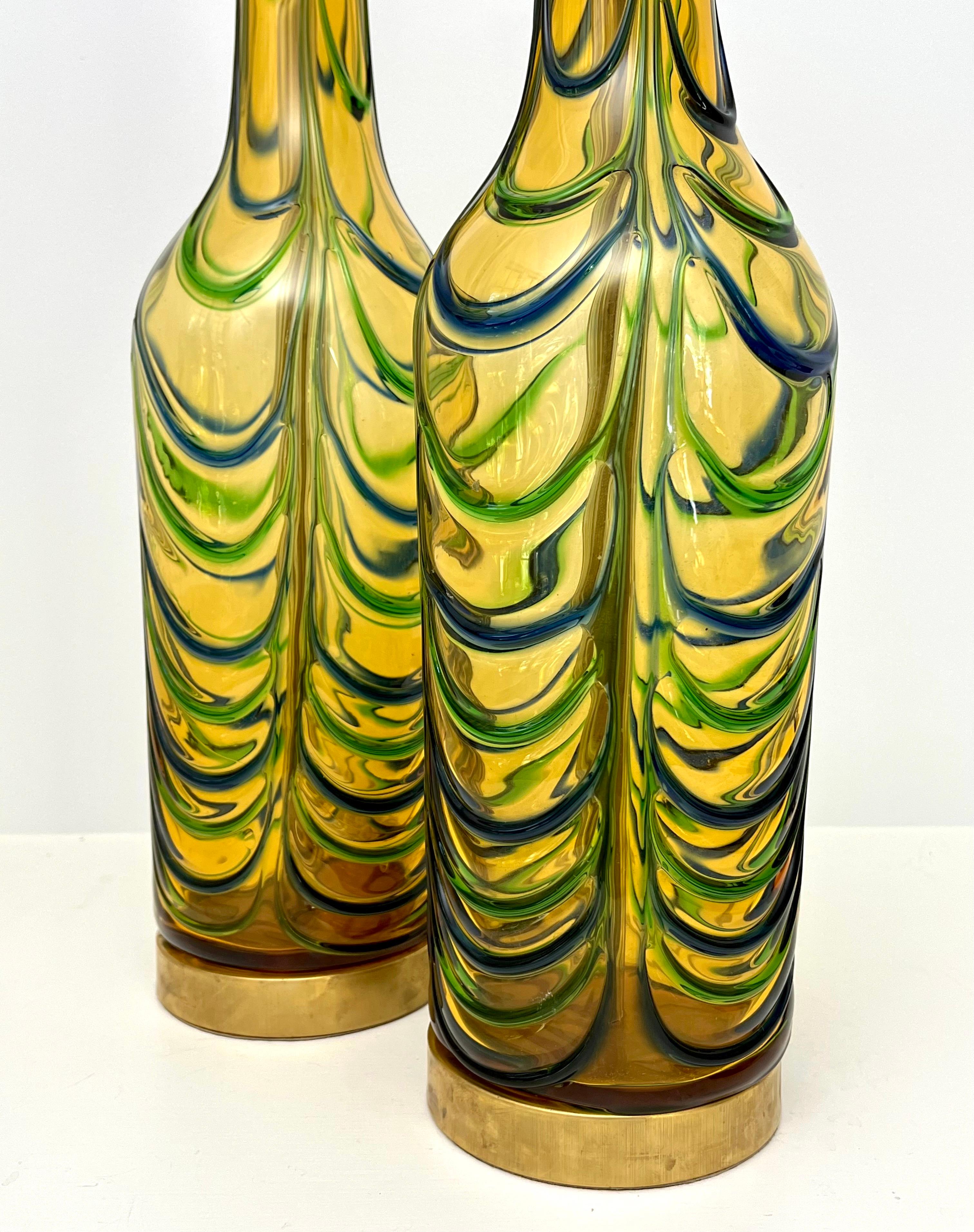 Stunning Pair of Mid Century Italian Murano bottle table lamps by Seguso. These are unique handblown lamps with blue and green waves on a yellowish gold background. A great transitional design for both modern and traditional decor with impressive
