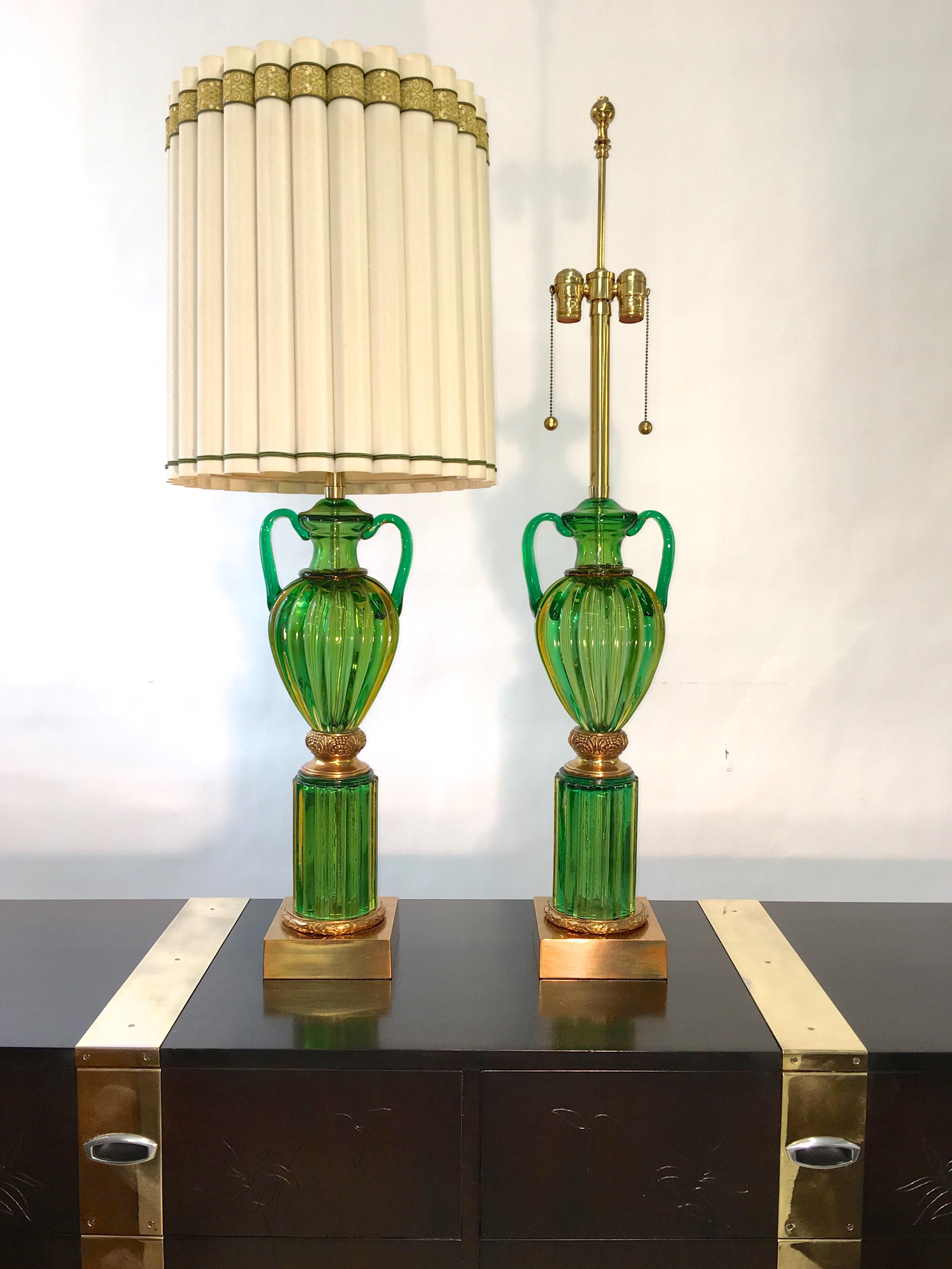 Monumental pair of table lamps as fresh as when they were first made in the 1960s by Marbro Lamp Co with imported emerald green Seguso Murano glass and polished brass fittings.

44 inches high to top of finials. 35 inches high to top of