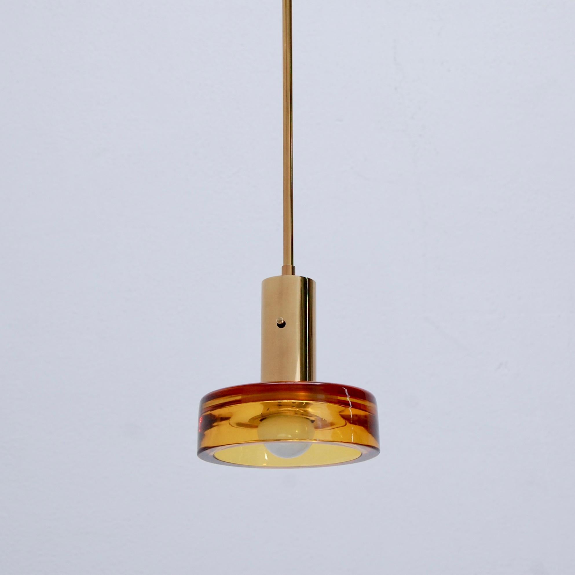 Pair of beautiful glass and brass pendants by Seguso of Italy. Seguso glass in sapphire blue and amber. Patina lacquered brass and partially restored. Each pendant is wired with a single E26 medium based socket for use in the US. Light bulbs
