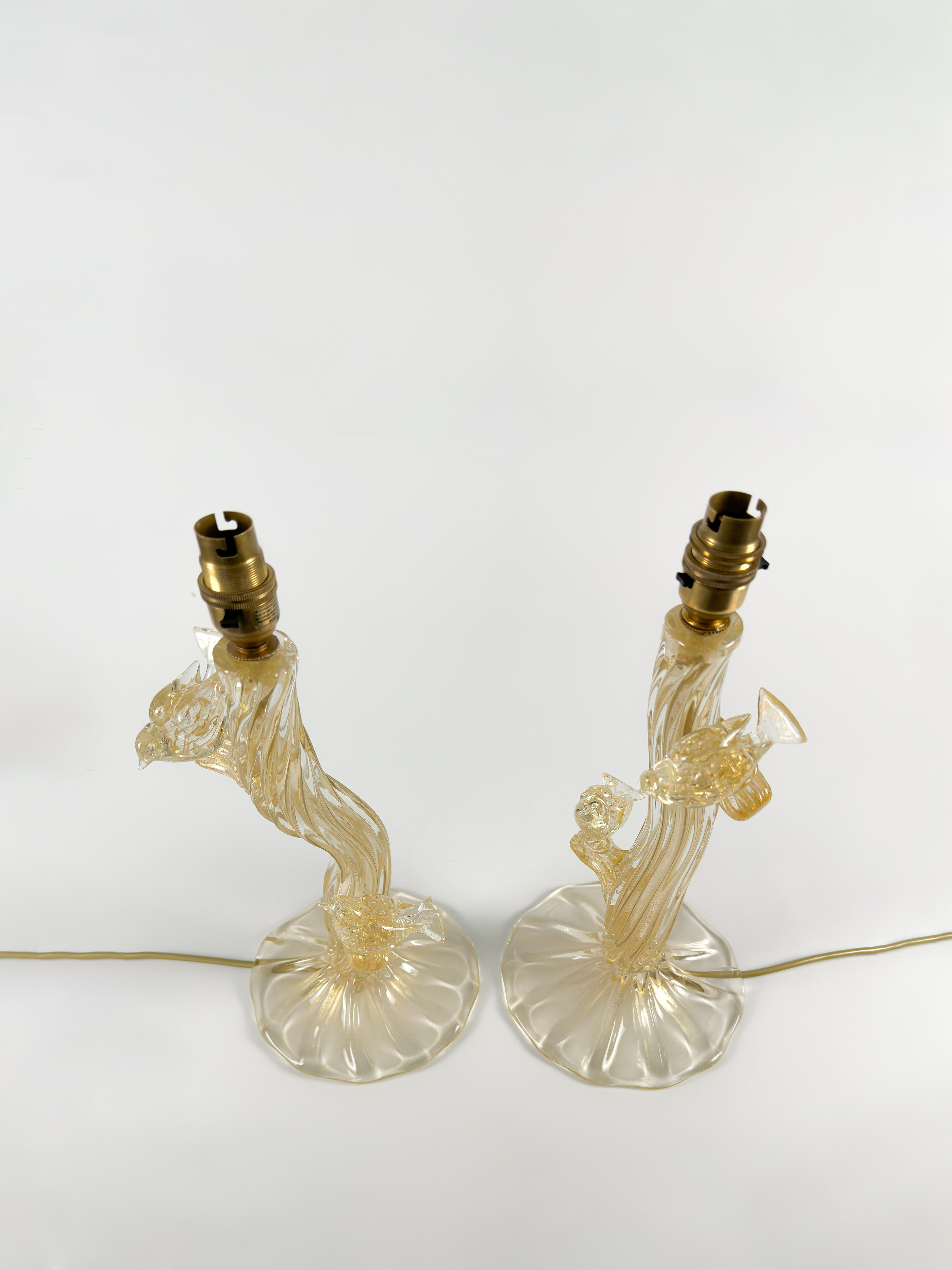 A distinctive and finely executed pair of Murano glass table lamps by Seguso Vetri d’Arte, dating to the early 1950s.

Each sculptural form evokes a stylised tree trunk with two delicate branches, from which a pair of small birds are quietly