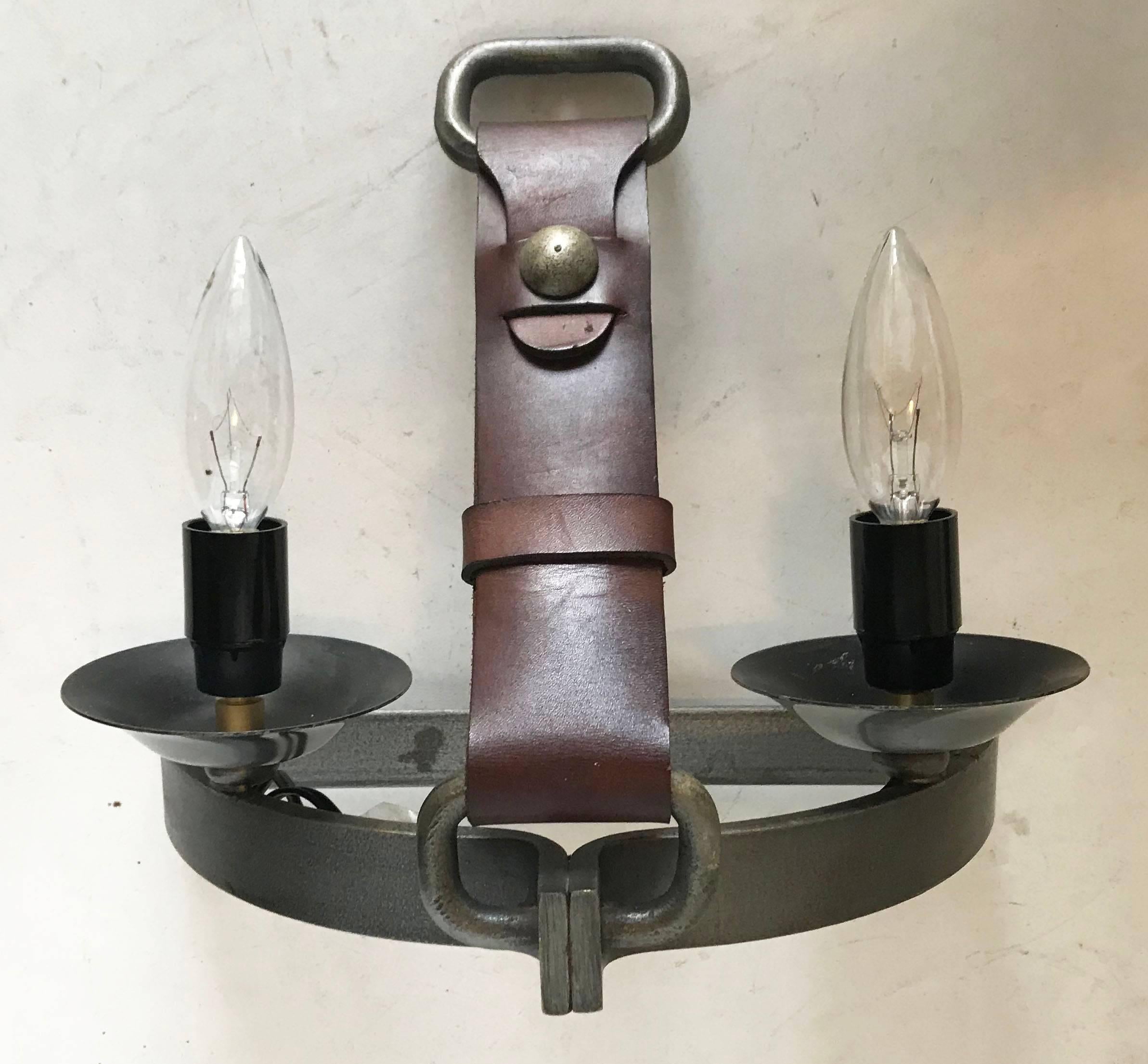 Gorgeous pair of sconces by Jacques Adnet style figuring a leather belt, holding a wrought iron frame.
Two lights, 60W watts per bulb
US wired and in working condition.