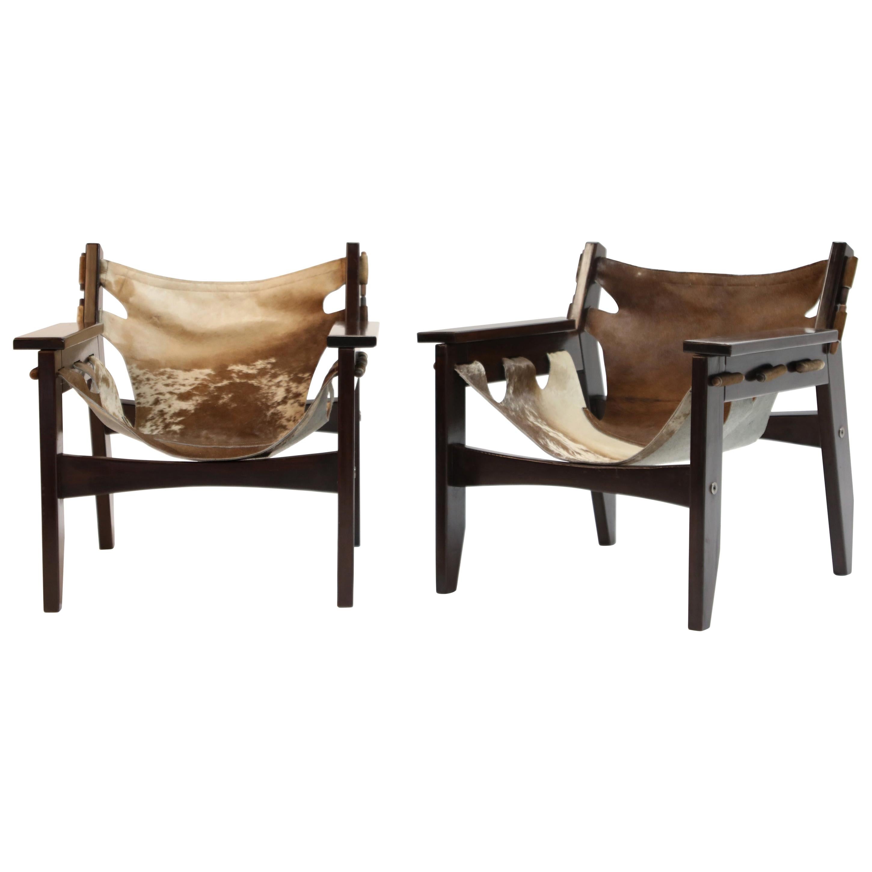 A charming pair and wonderful examples of 'Kilin' chairs by famed Brazilian modern designer Sergio Rodrigues for Oca in 1970s Brazil. Frame is a succulent Brazilian Rosewood and the leather slings are hair-on cowhide. The pattern on each sling is