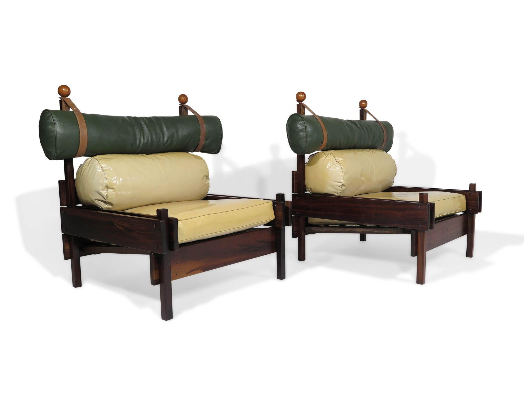 Stunning Pair of Sergio Rodrigues Tonico lounge chairs produced by OCA/Meia-Pataca in Brazil, 1962. The chairs are constructed of solid Imbuia wood and feature the original vinyl cushions with leather belts for the sculptural headrest. The cushions