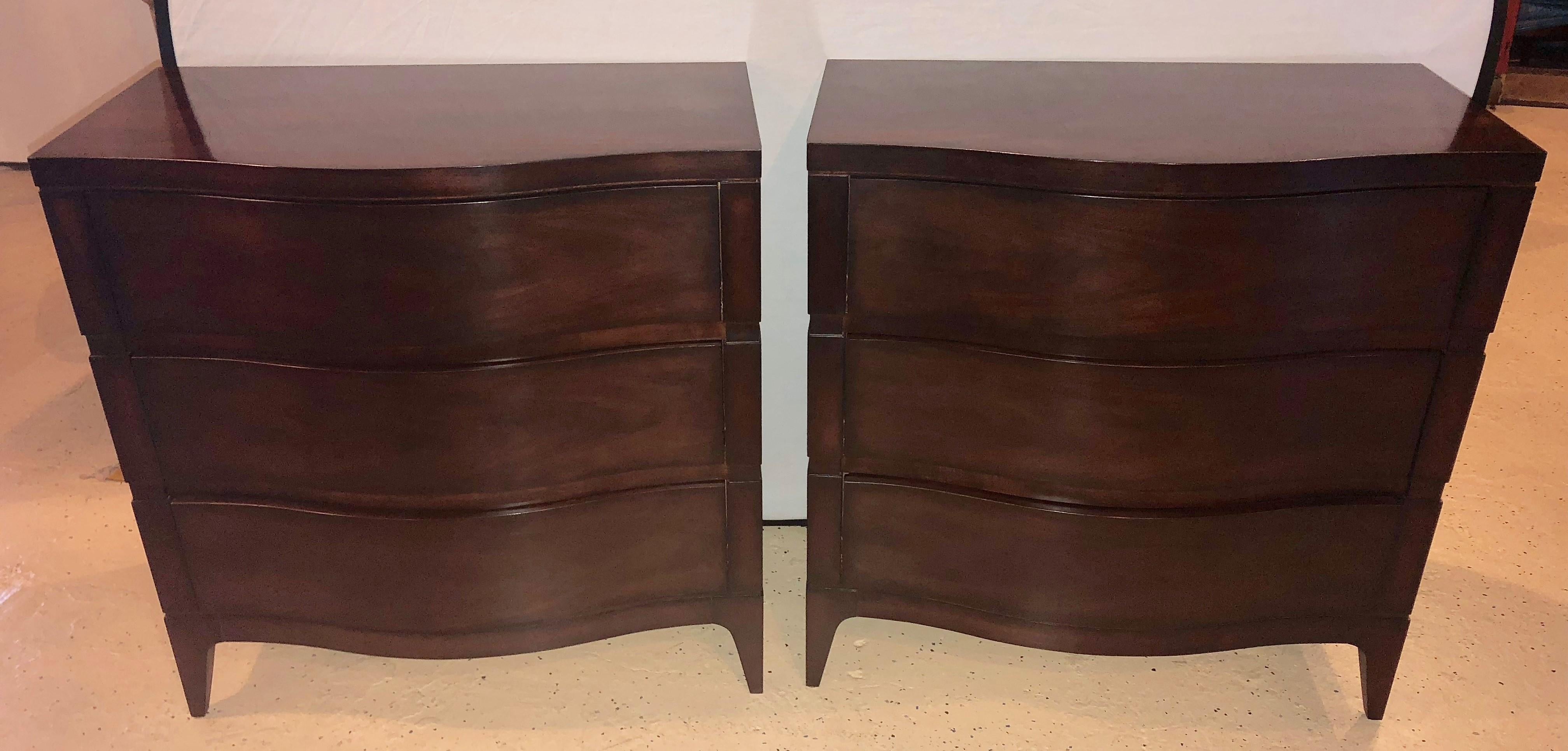 Pair of serpentine front Mahogany chest or nightstand commodes by the Hickory white furniture company. Each having three curved front drawers on spade feet with brick corners with box cut-out sides. Fine condition.