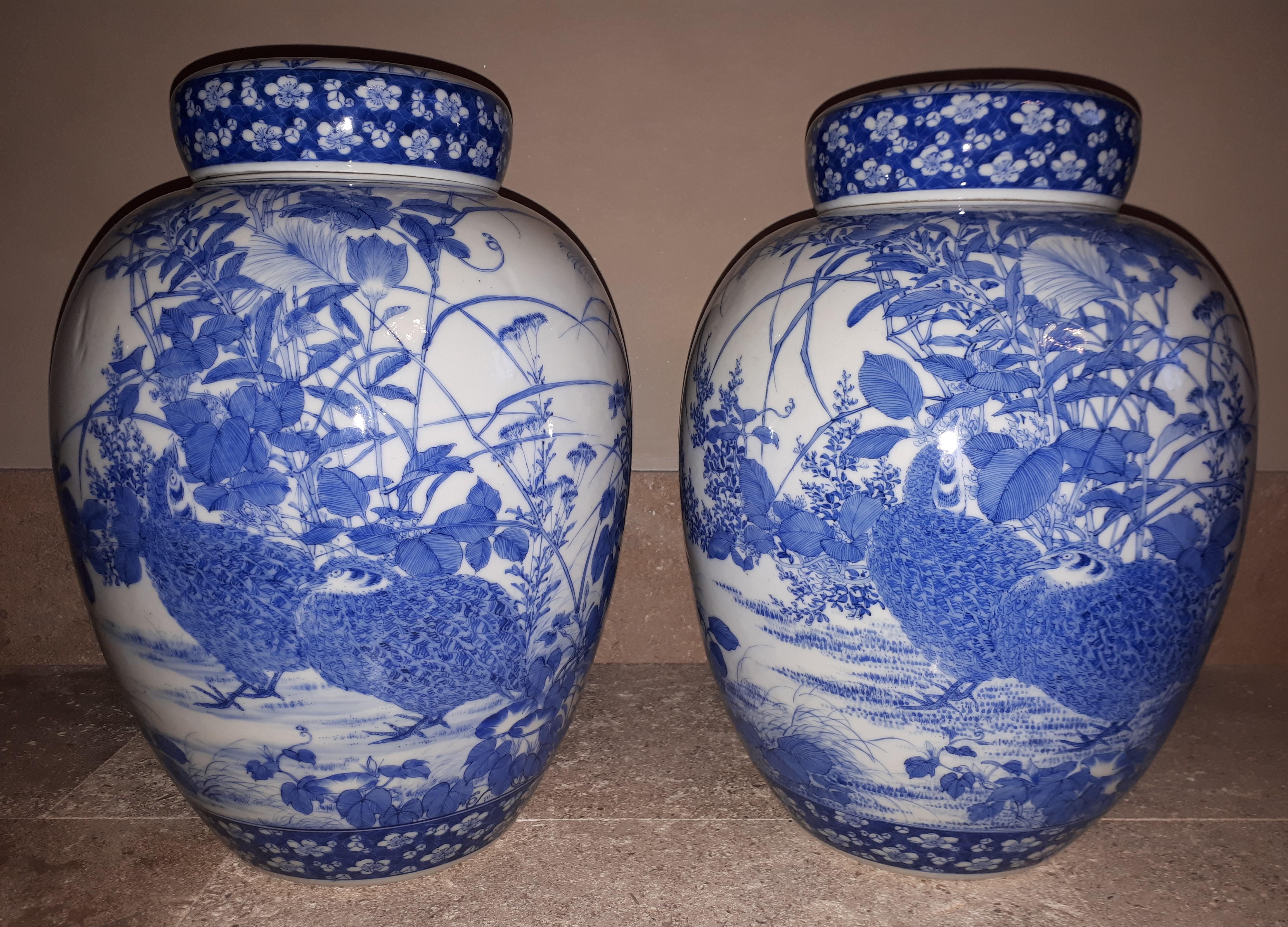 Magnificent pair of porcelain vases with a rich underglaze blue decoration of a couple of partridges among the vegetation. A minimal defect on each interior lid in the shape of a stylized lotus flower (a tiny hair on one, a small piece glued on the