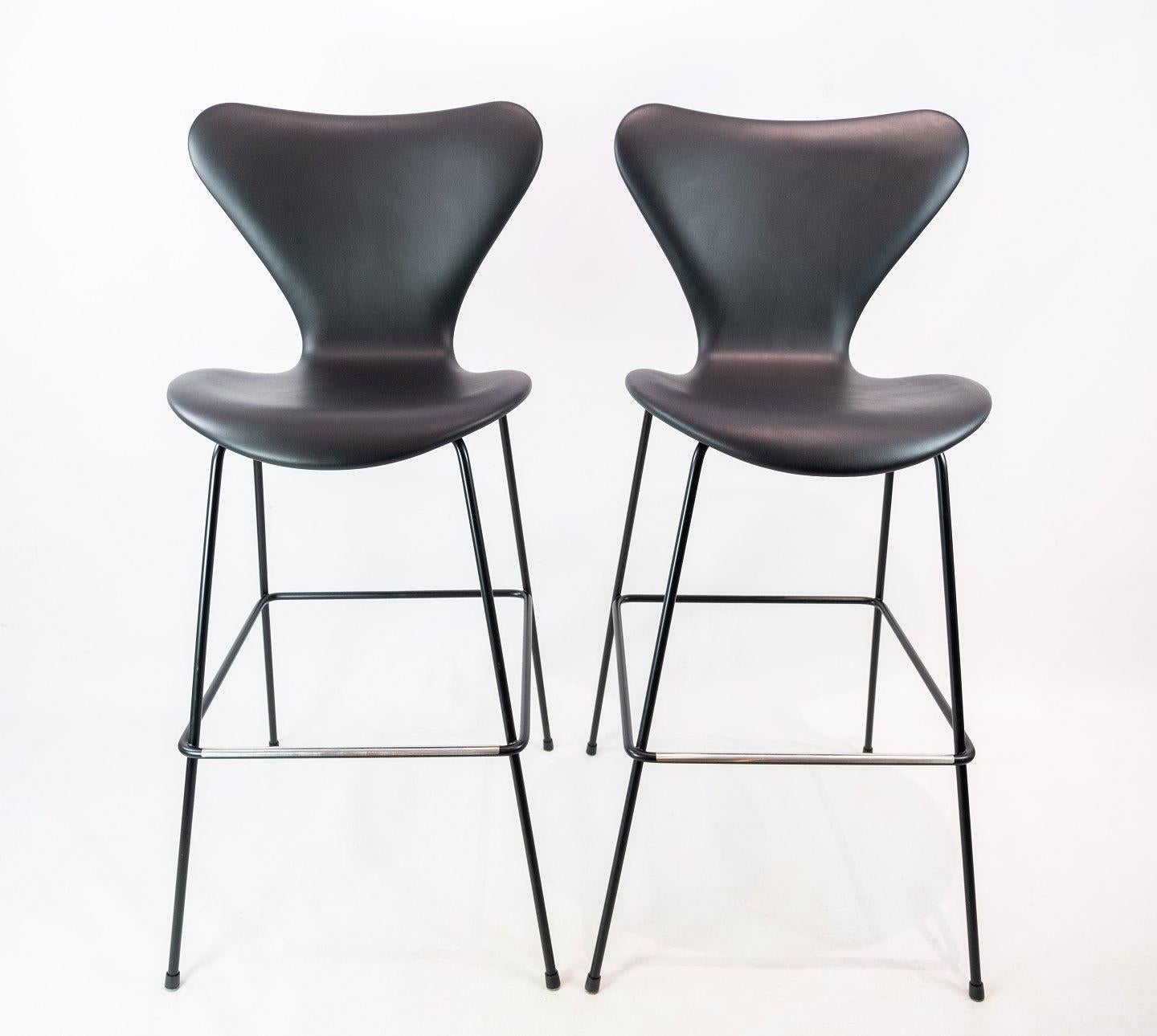 A pair of seven bar stools, model 3187/3197, by Arne Jacobsen and Fritz Hansen. The stools are with original upholstery of black leather.
   