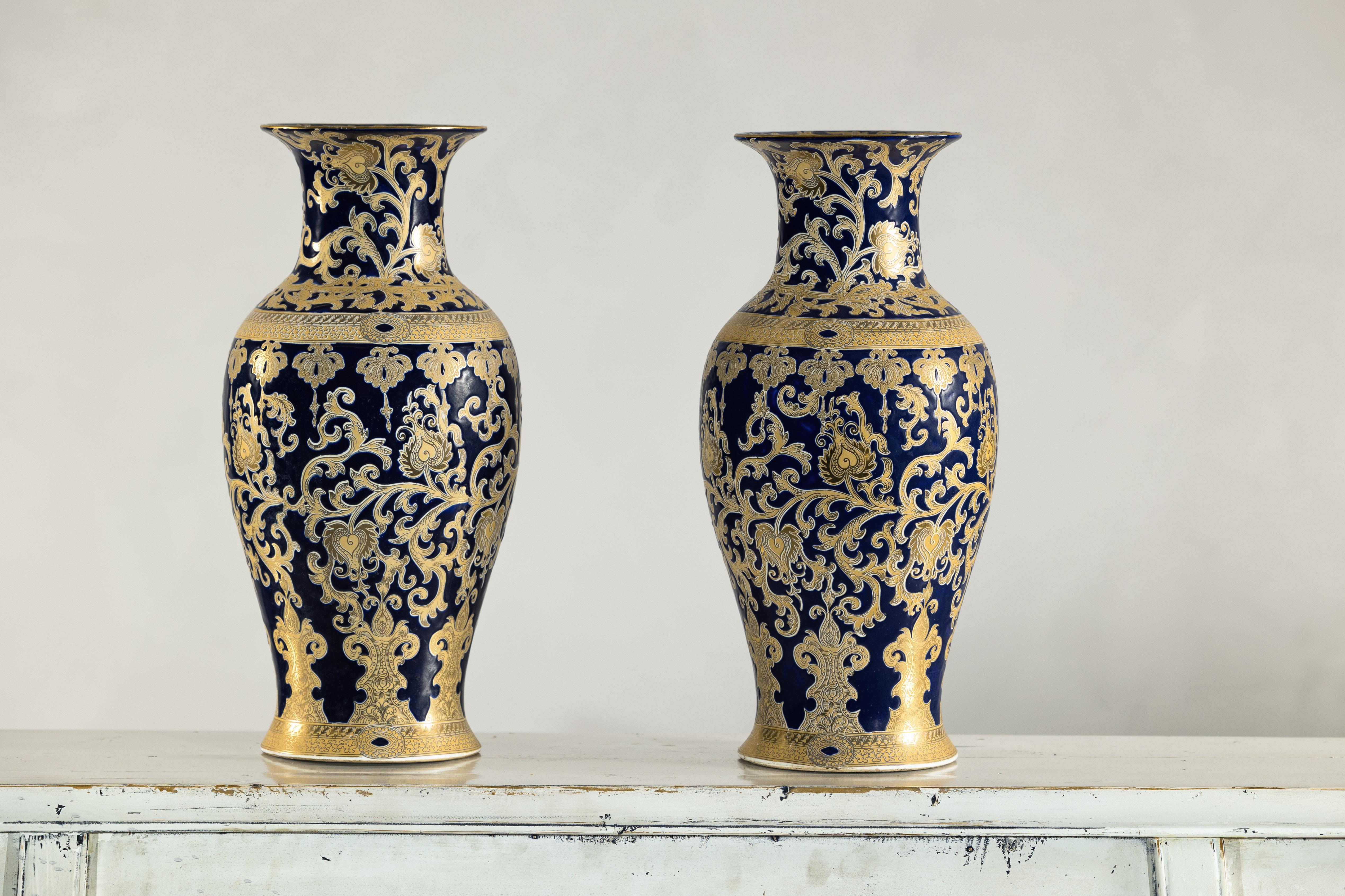 Coppia di vasi in porcellana blu cobalto e oro di ispirazione Sèvres, ornati da intricati motivi a fogliame e arabesco. Questi vasi richiamano la raffinata eleganza della porcellana francese di Sèvres del XVIII secolo, con il loro profondo smalto