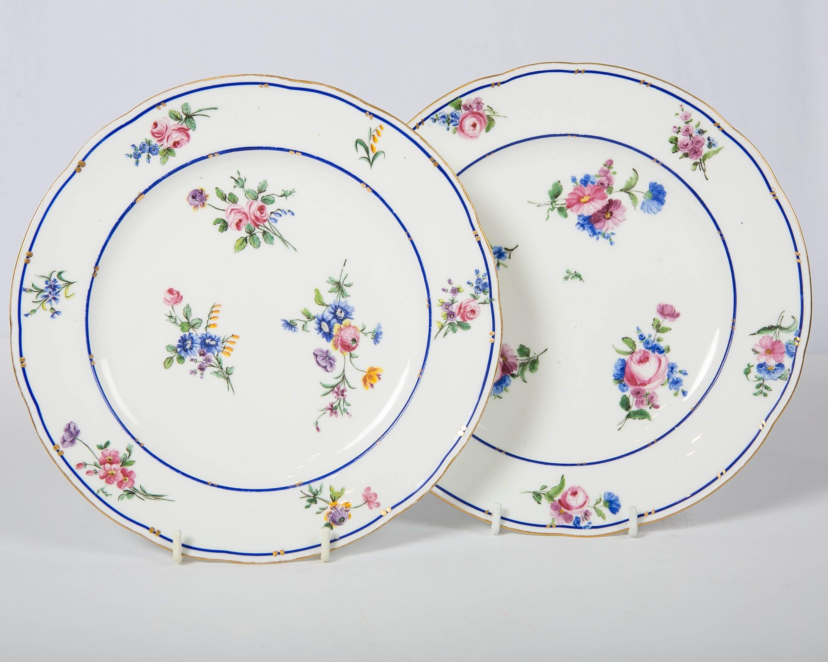 Ein Paar Porzellanschalen aus Sèvres aus dem 18. Jahrhundert, hergestellt um 1785. Sie sind mit exquisiten Blumensträußen in zartem Rosa, Blau, Lila und Gelb bemalt. Der Rand und die Kante sind mit einer feinen emaillierten blauen Linie und einer