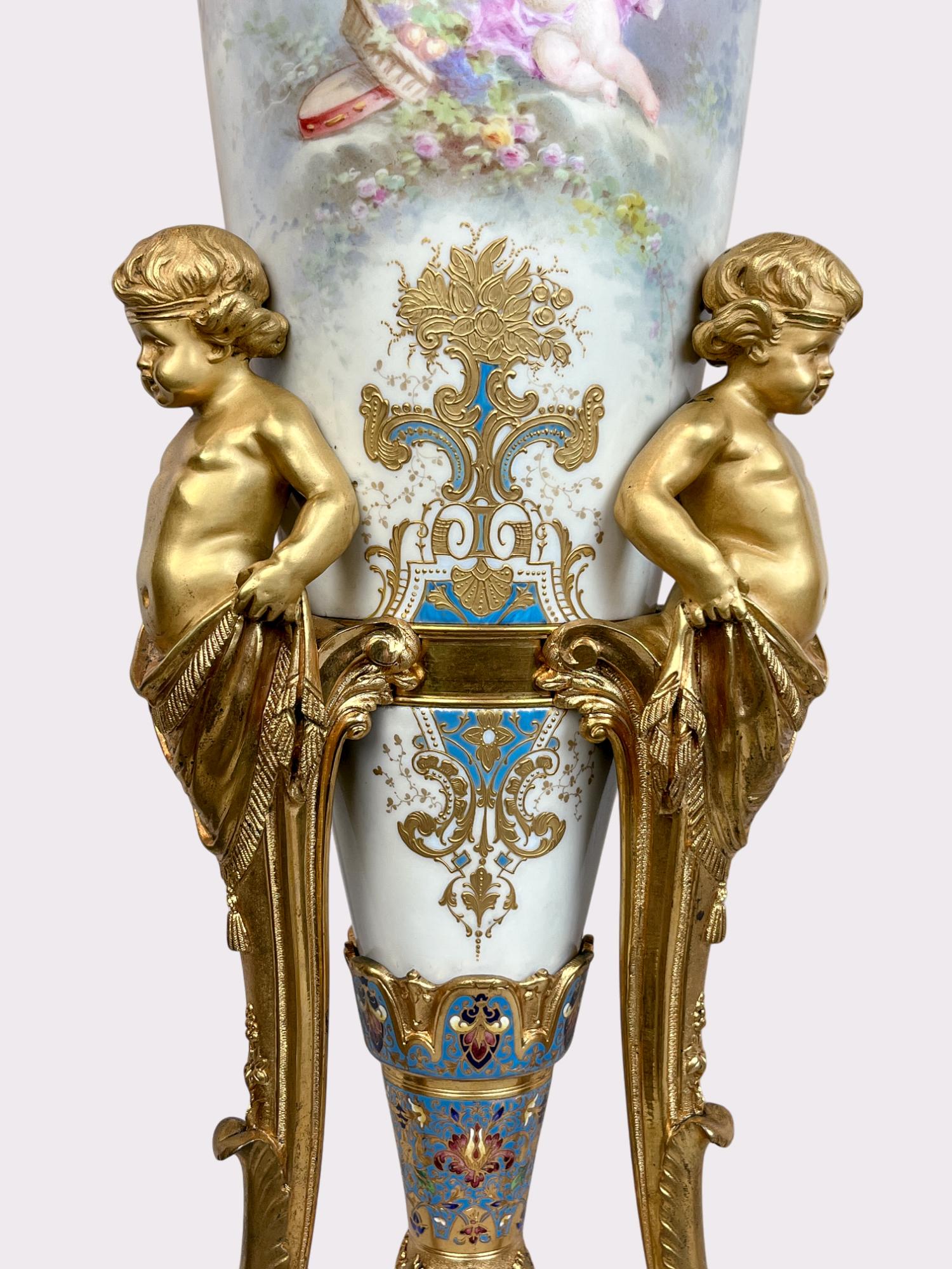 Coppia di vasi con montatura in ormolu in stile Sèvres 

Coppia di vasi in bronzo dorato e smalto champleve su tre supporti figurati a cherubino con piedi a zampa. Anfore dipinte a mano con scene di putti sul fronte e nature morte con flora e