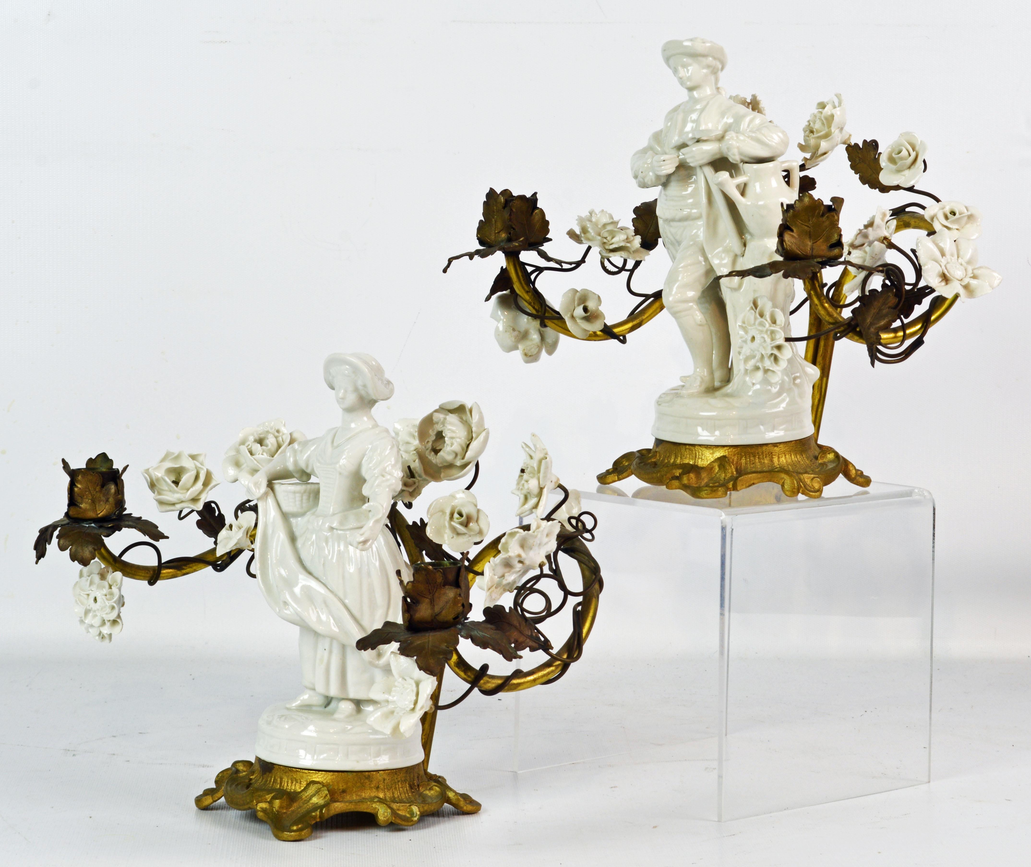 Dating to the late 19th century this pair of French Sevres style candelabras features blanc de chine porcelain central figures of a young man and a young woman as gardeners mounted upon Rococo style gilt bronze bases. The two light arms, richly