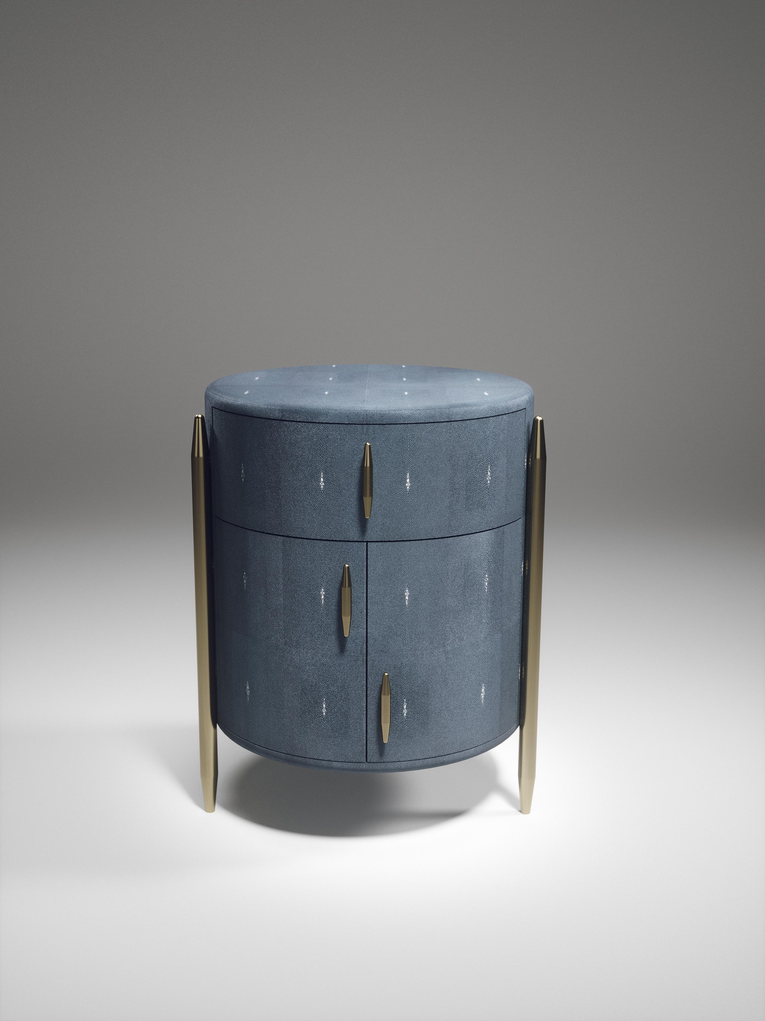 The pair of dandy round bedside tables by Kifu Paris are elegant and luxurious home accents, inlaid in dark denim blue shagreen with bronze-patina brass details. This piece includes 1 drawer total and a cabinet below; the interiors are inlaid in