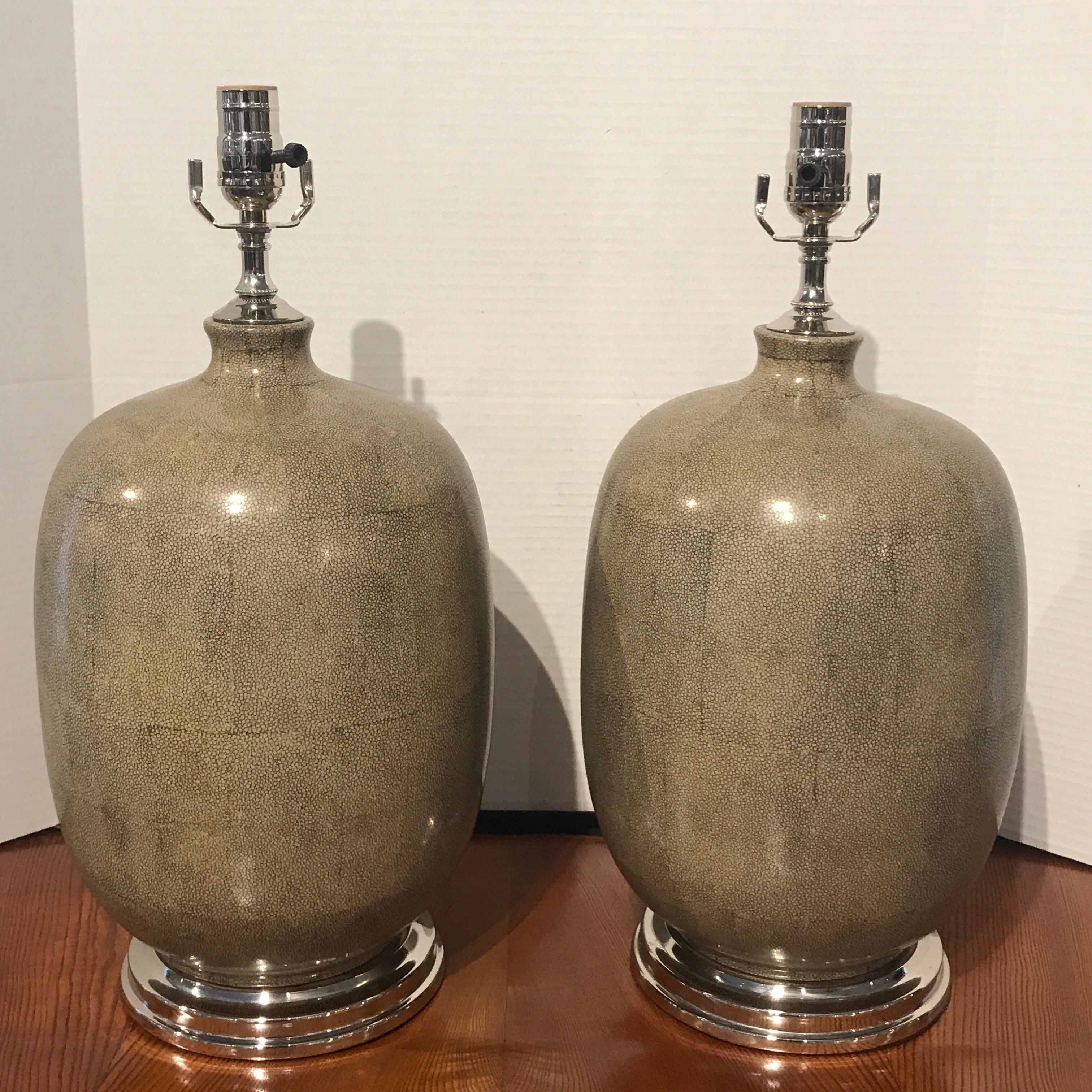 Pair of Shagreen porcelain vases now as lamps, finely painted with bookmatched shagreen pattern, with silver plated mounts. New wiring. Each lamp stands 20