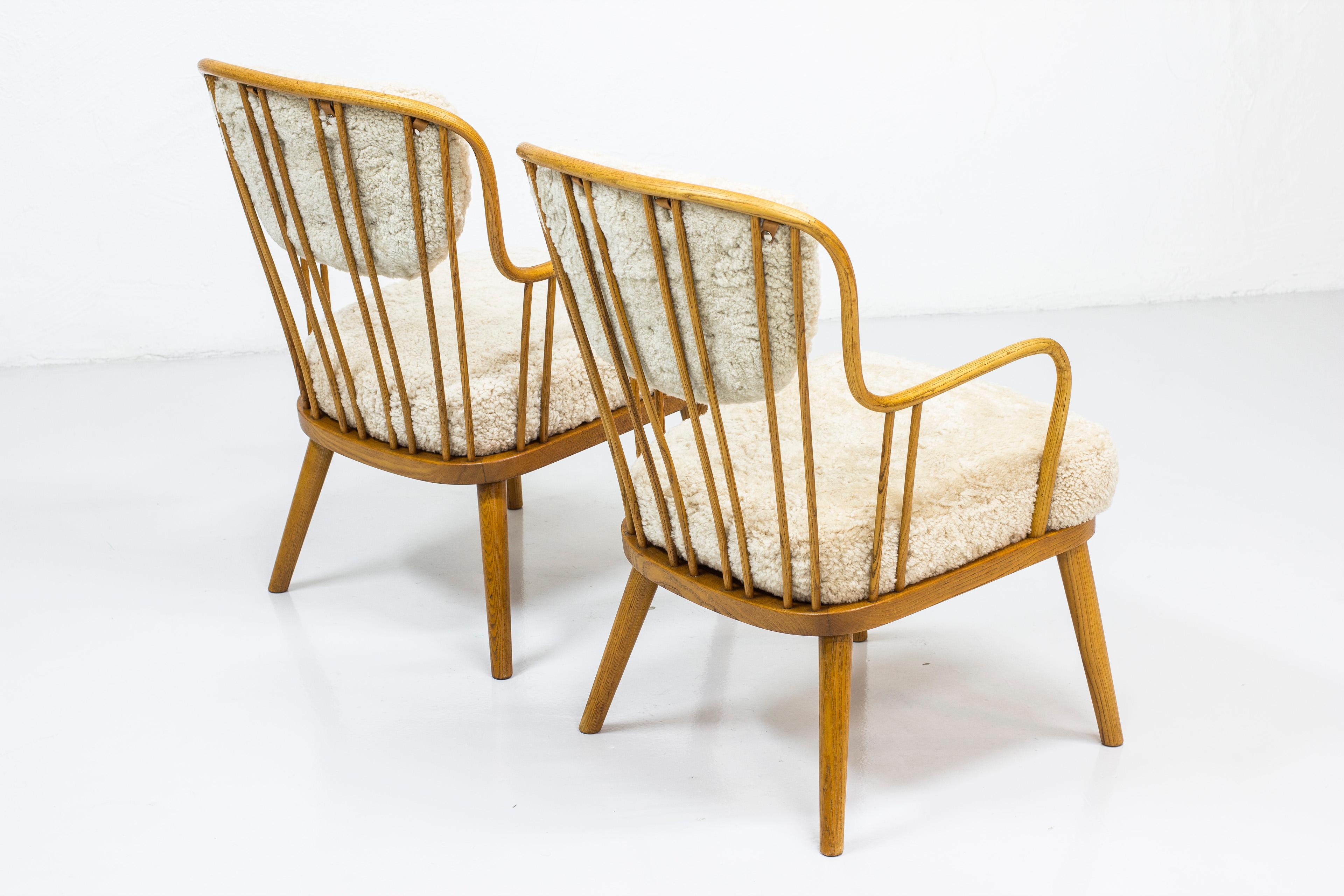 Pair of sheepskin easy chairs by Aage Herman Olsen, Denmark, 1940s a easy chairs designed by Danish interior architect Aage Herman Olsen. Produced by Kocks Snickerier in Sweden during the 1940s. Made from oakwood with steam bent oak arm- and