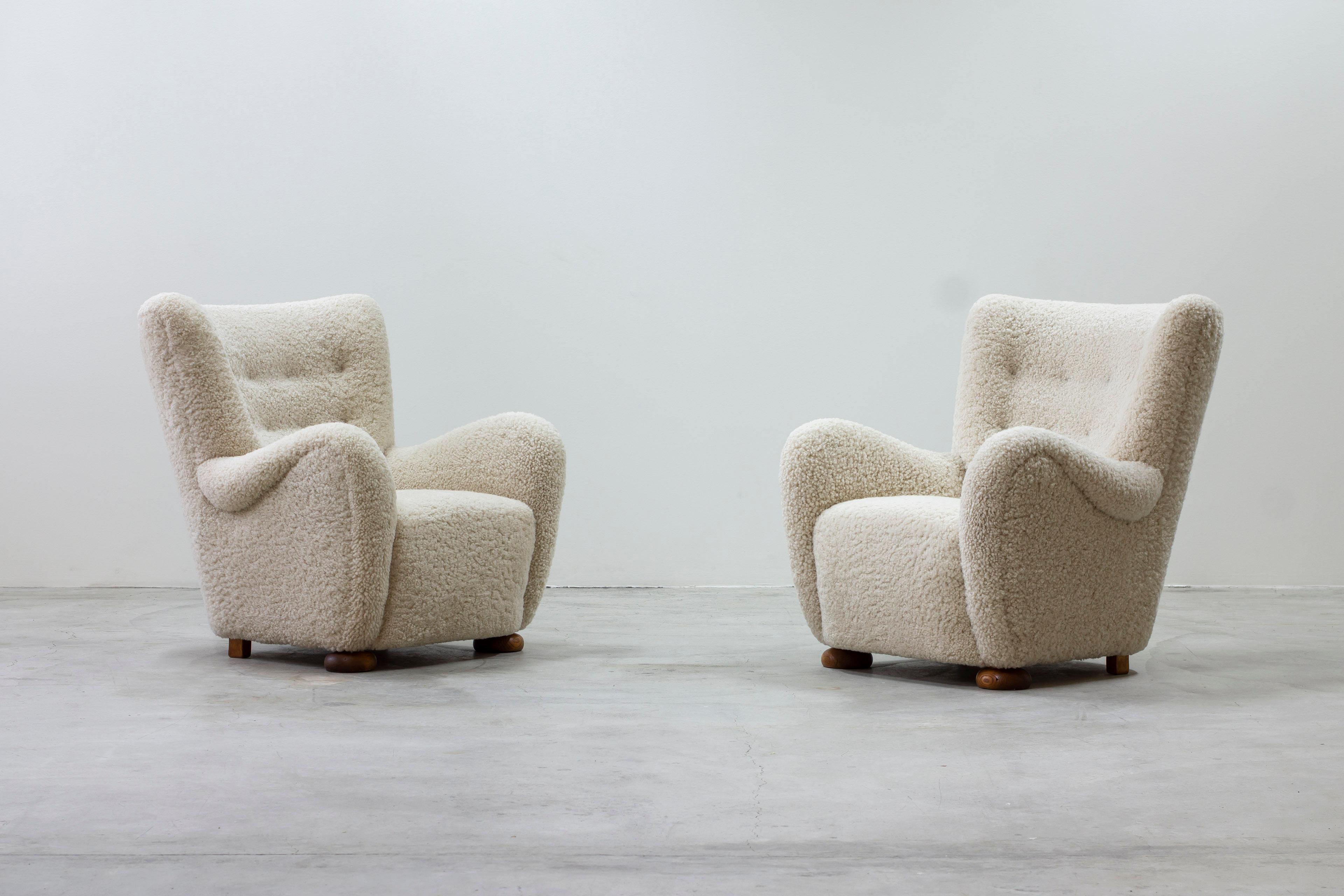 Pair of lounge chairs in the manner of Märta Blomstedt. Designed and produced in Denmark by Danish cabinetmaker. Legs in oak and off white sheepskin upholstery. Upholstery is new and in excellent condition. Very good condition with few signs of