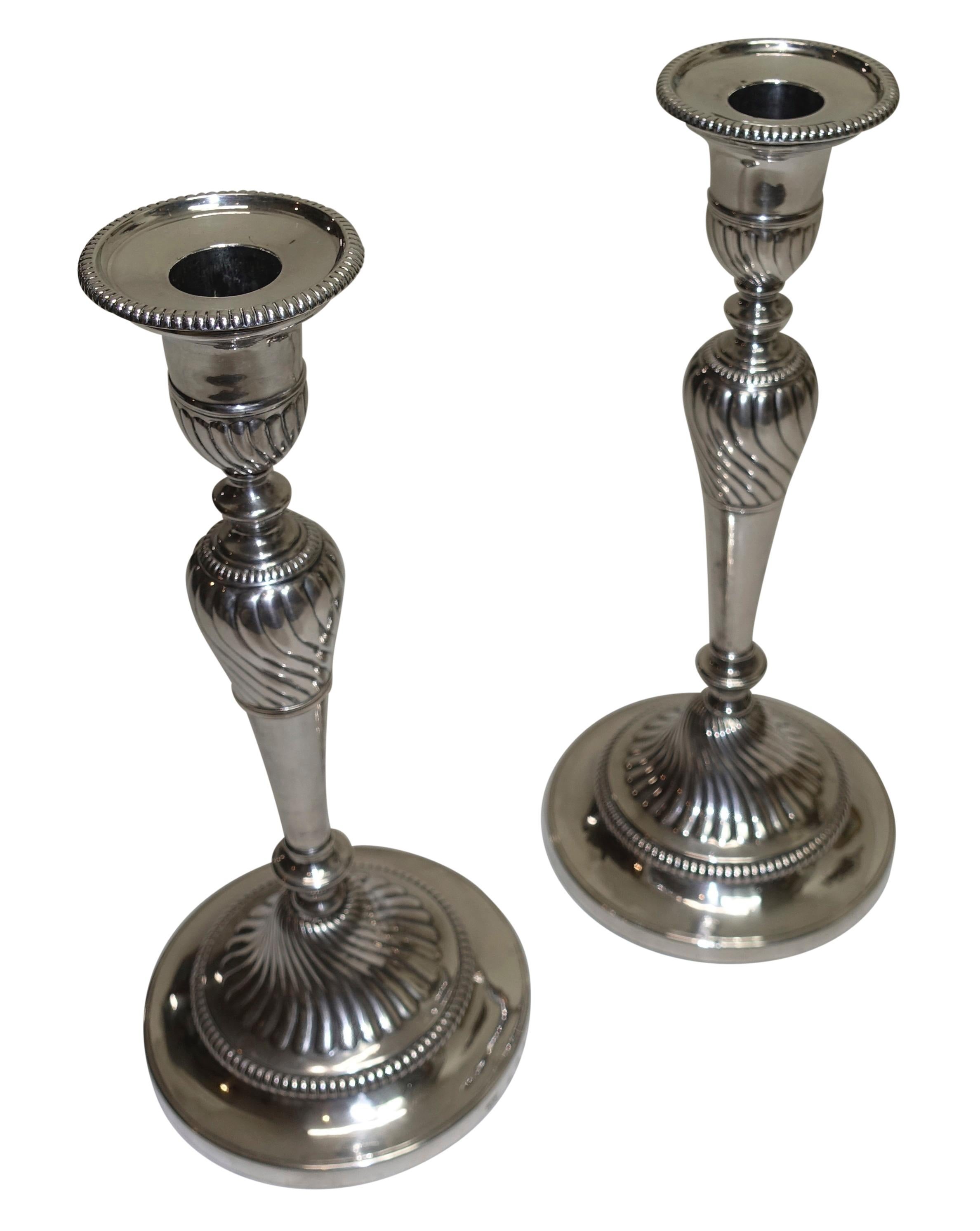 A pair of George III sterling silver candlesticks with weighted bases made by I G & CO., John Green, Roberts, Mosley & Co. Fully hallmarked on the bases and the bobeche, England, late 18th-early 19th century.