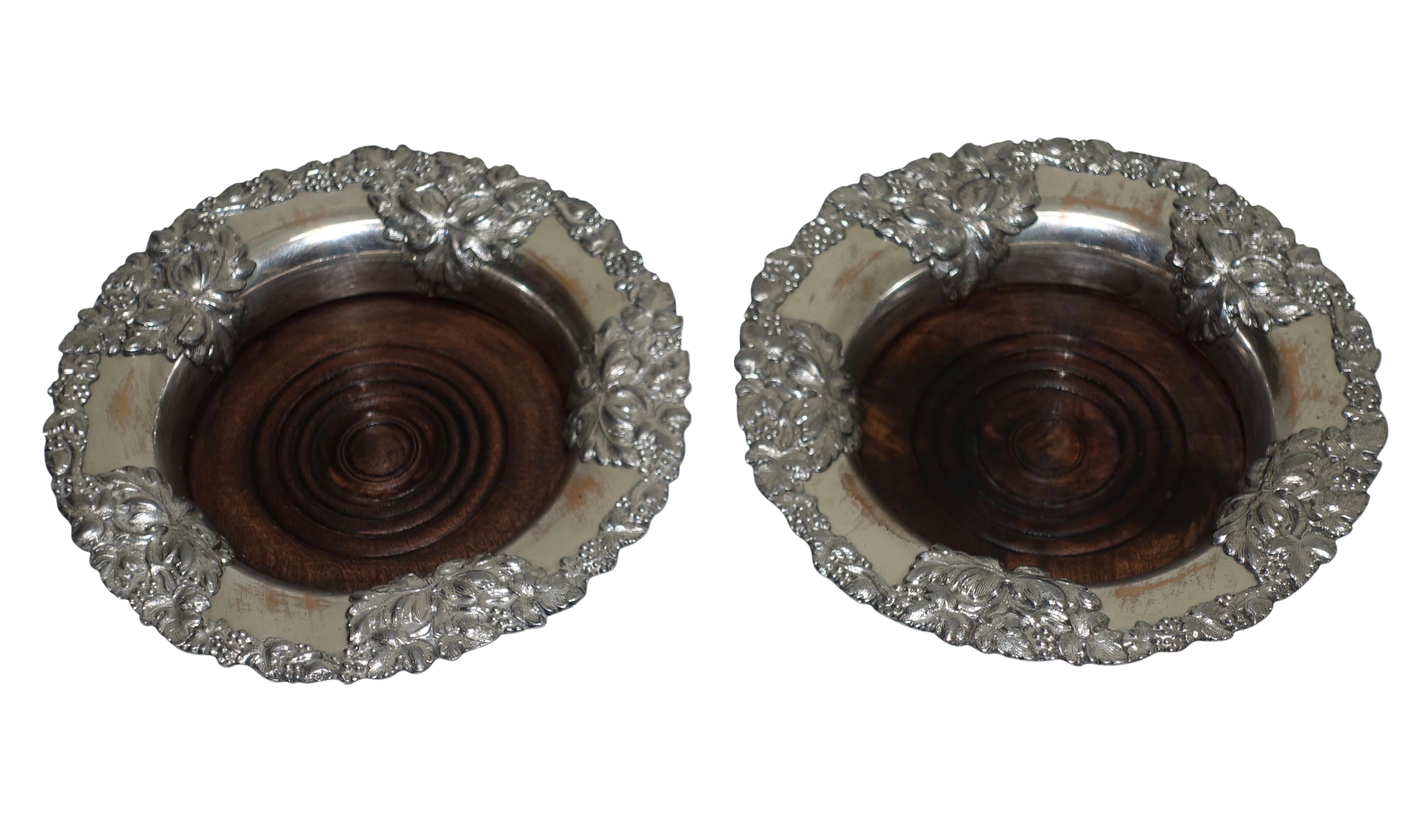 A pair of antique Sheffield silver plate wine coasters with grape leaves, a grape design border and inset wood bottom. England, 19th century, circa 1860.
   
    