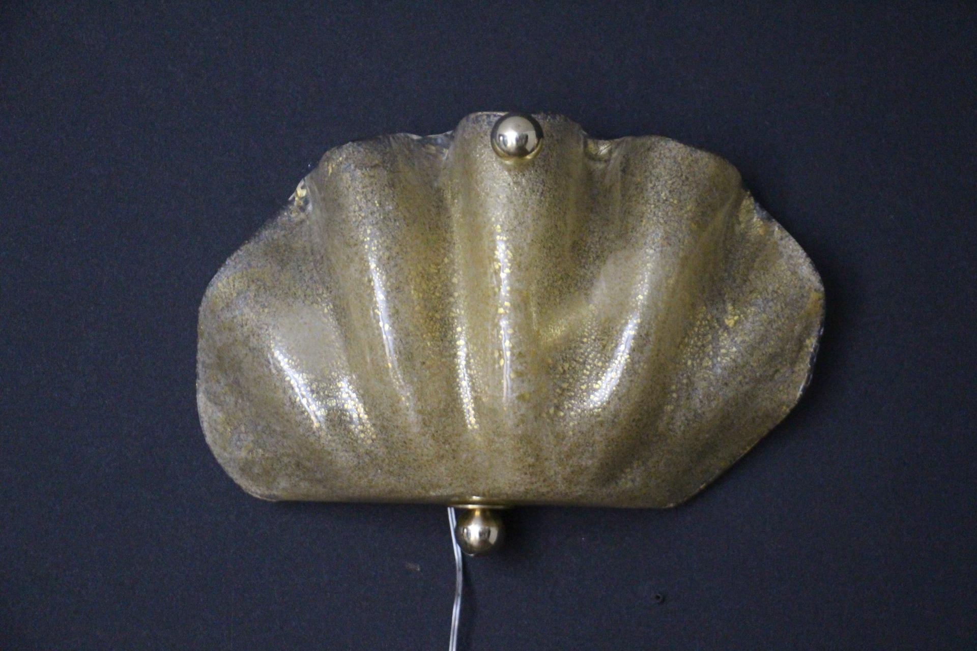 Este magnífico par de apliques fue fabricado totalmente a mano por artesanos altamente cualificados en Murano . Es de cristal de Murano soplado a mano y trabajado con inclusiones de polvo y escamas de oro de 24 quilates. Presenta una elegante