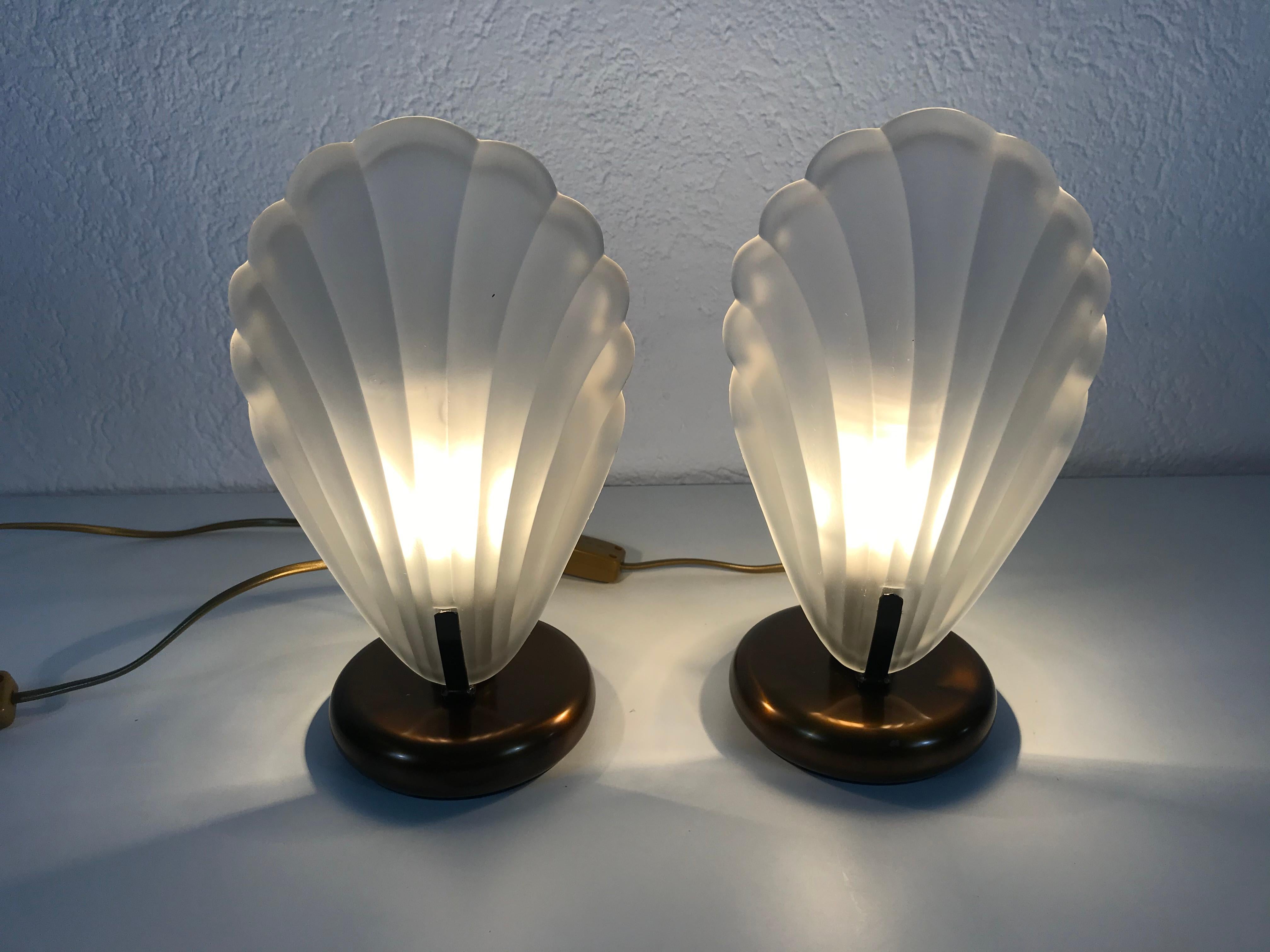 A beautiful pair of table lamps by AF Cinquanta made in Italy in the 1980s. They have a shell shape and are made of ice glass. The original brand label is on both of the lights. They are in very good vintage condition.

The light requires one E14