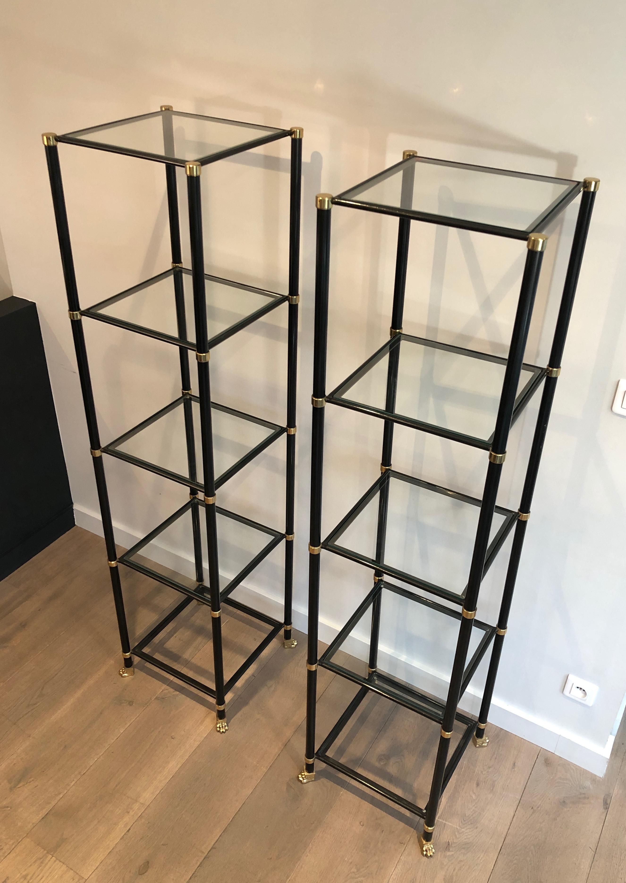 This stunning pair of shelves ar emade of black lacquered metal, brass and bronze glass shelves. The bottom legs of each vitrine has very nice bronze claw feet that are specific from the designer. This is a work by famous French designer Guy Lefevre