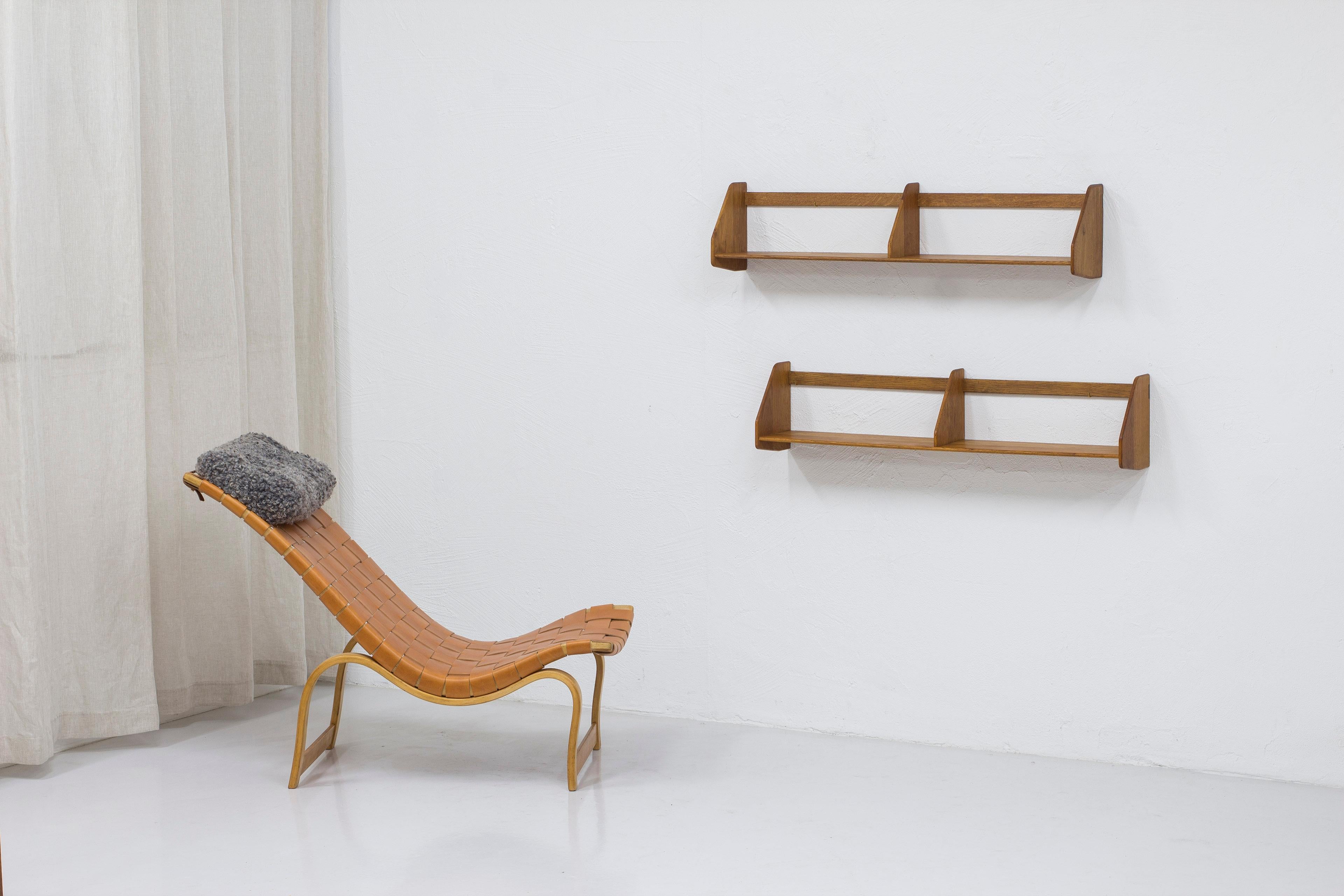 Pair of shelves model RY21 designed by Hans J. Wegner. Produced in Denmark by RY Møbler during the 1950s. Made from solid oiled oak. The back pieces have not been screwed through which is very common. Instead the shelf is hung on small brass hooks.