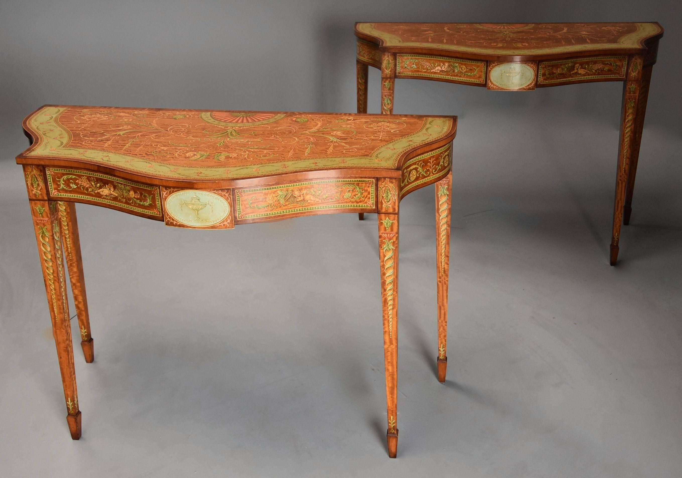 A superb pair of Sheraton revival highly decorative satinwood and painted serpentine shaped console tables.

This pair of tables consist of superb and finely painted satinwood tops of typical Adam style Classical decoration including fan,