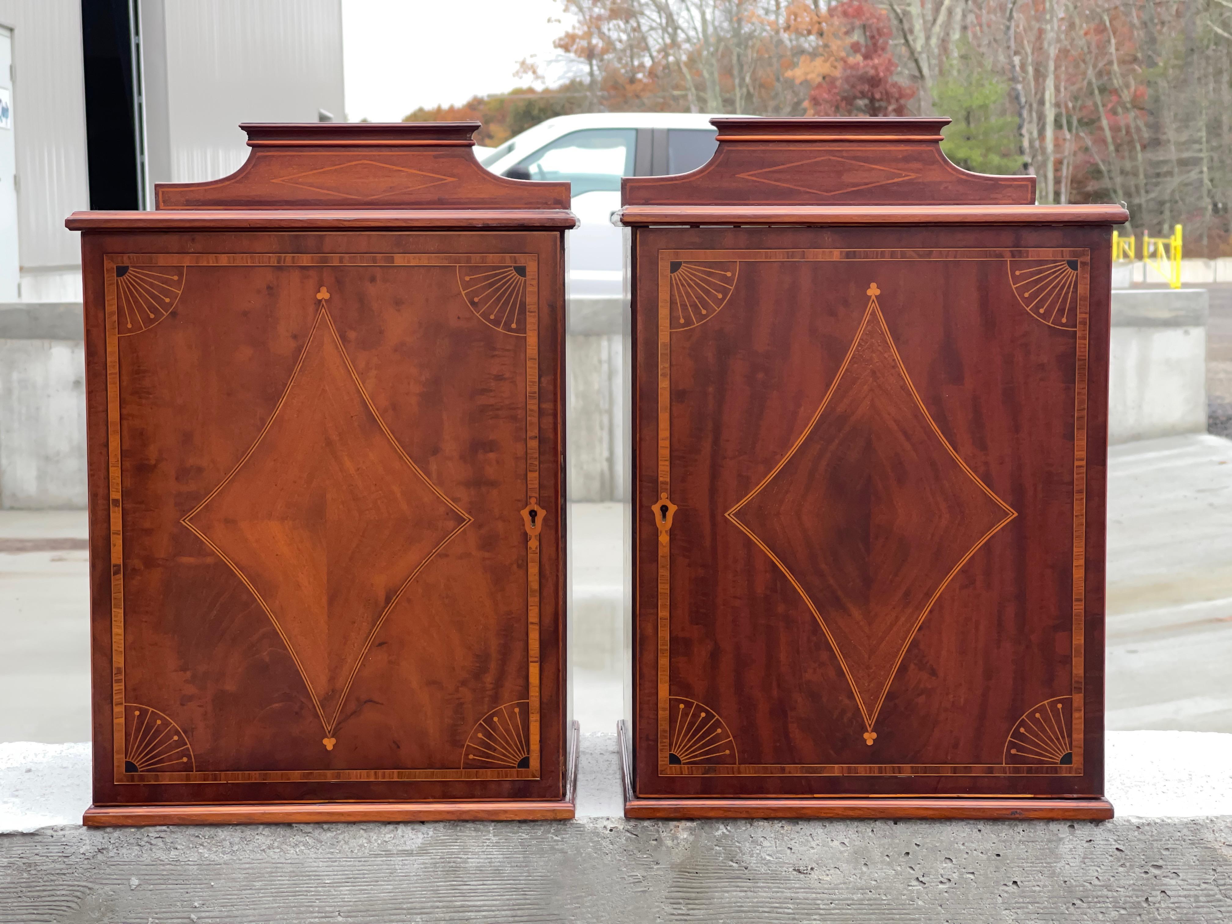 Pair of interesting and lovely single door walnut cabinets with satinwood decorative inlay, probably Edwardian made in the Sheraton taste.
Each has a single pull-out open drawer shelf.
Possibly bedside lockers or for tobacco.
Last image shows