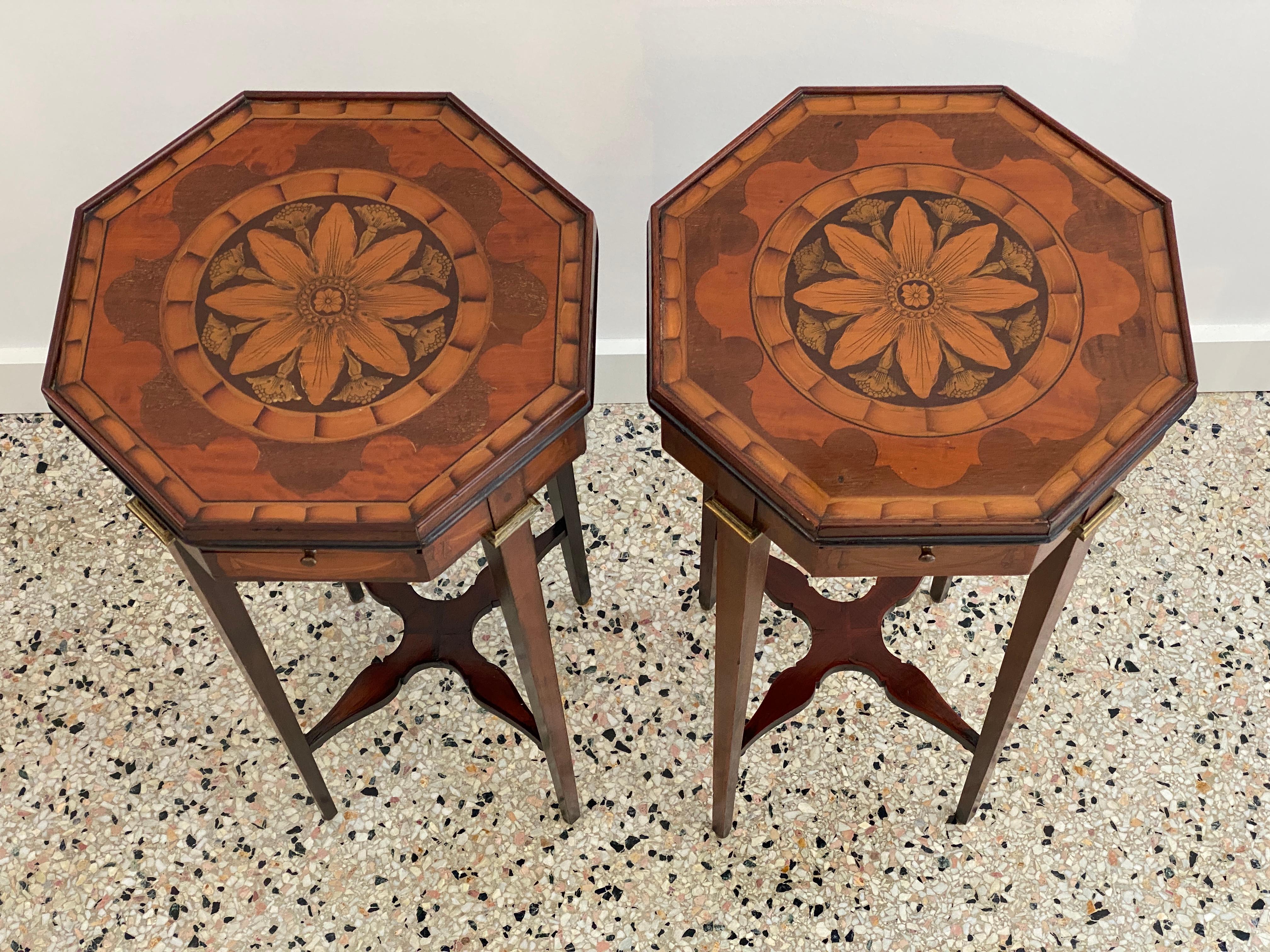 This stylish and chic pair of octagonal shaped side tables are very much in the style of pieces created by Sheraton and Adams.  They are fabricated with marquetry inlaid woods, with detail of a stylized flower and fabric swags. 

And the pull out