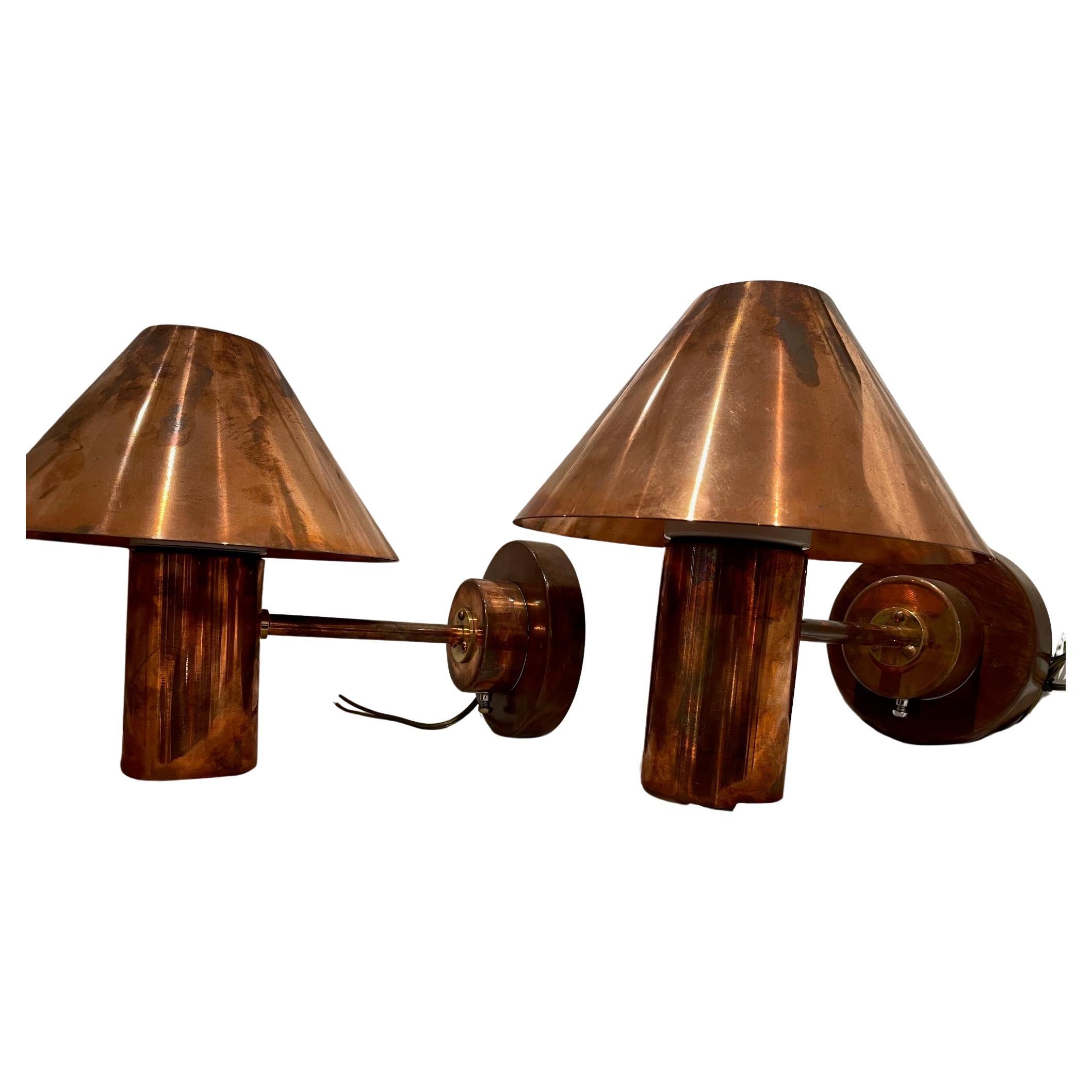A pair of copper bunk lights from the quarters of a decommissioned ship.  Mounted on teak back plates and complete with copper shades.  Porcelain light bulb socket..  Originally European; rewired for American use.  Circa 1970's.

The Lockhart