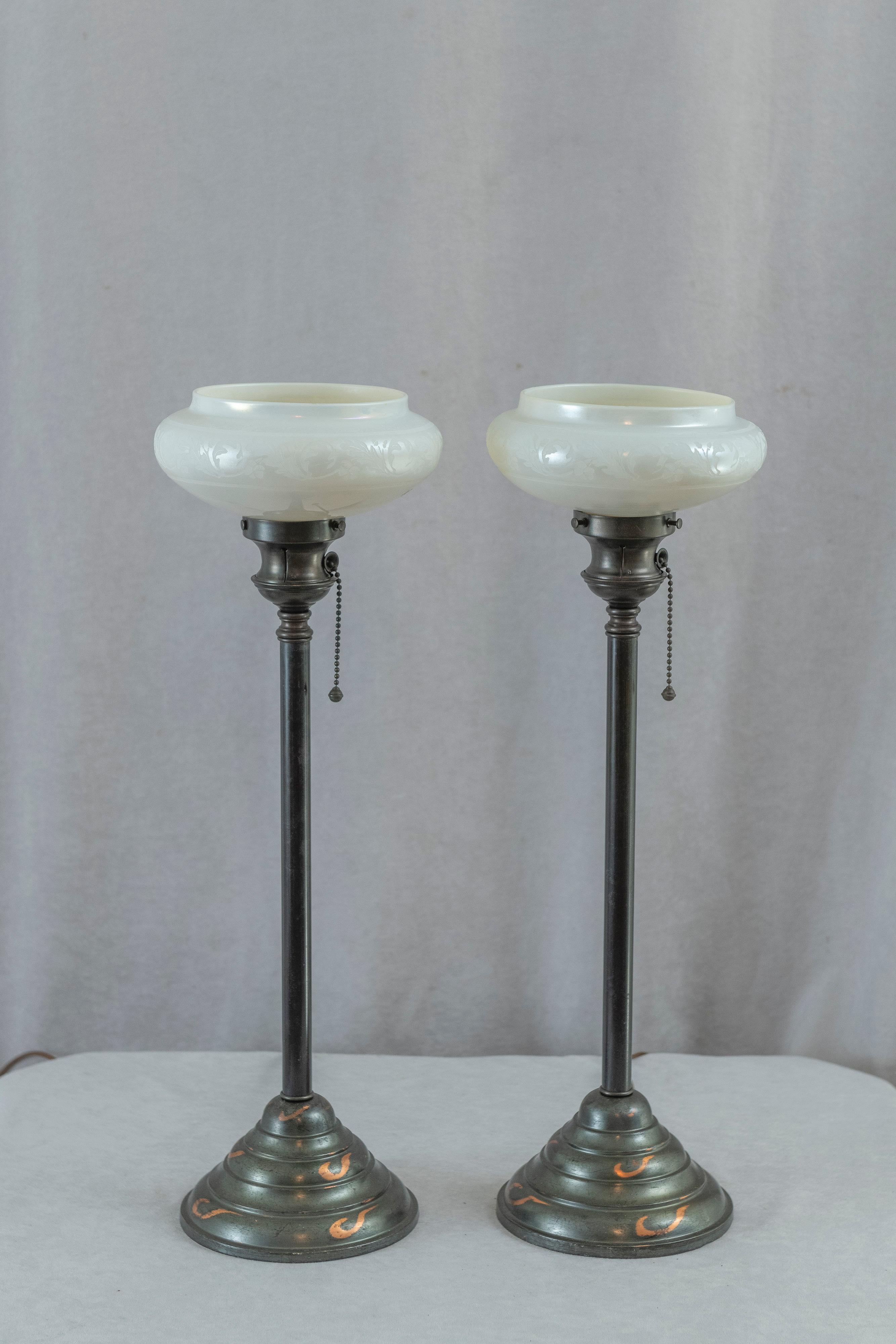  This very handsome pair of torchiere lamps consist of richly factory patinated bronze bases and hand blown glass by the noted maker, Steuben. The glass is what is termed 