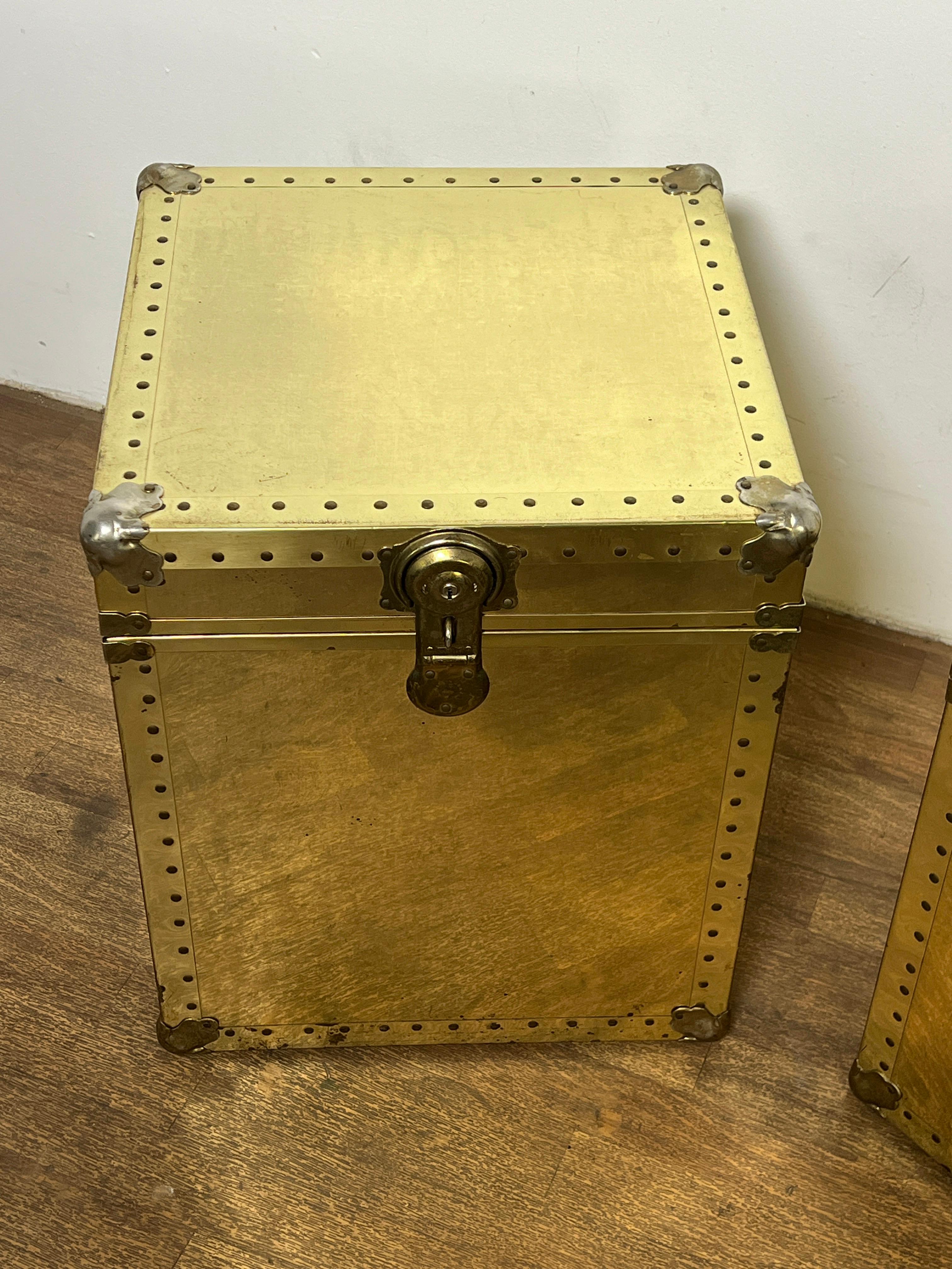 Pair of brass clad cube form trunks, perfect height for use as end tables. Manufactured by Drescher, circa 1970s, in the style of Sarreid.  Two working keys included.

18