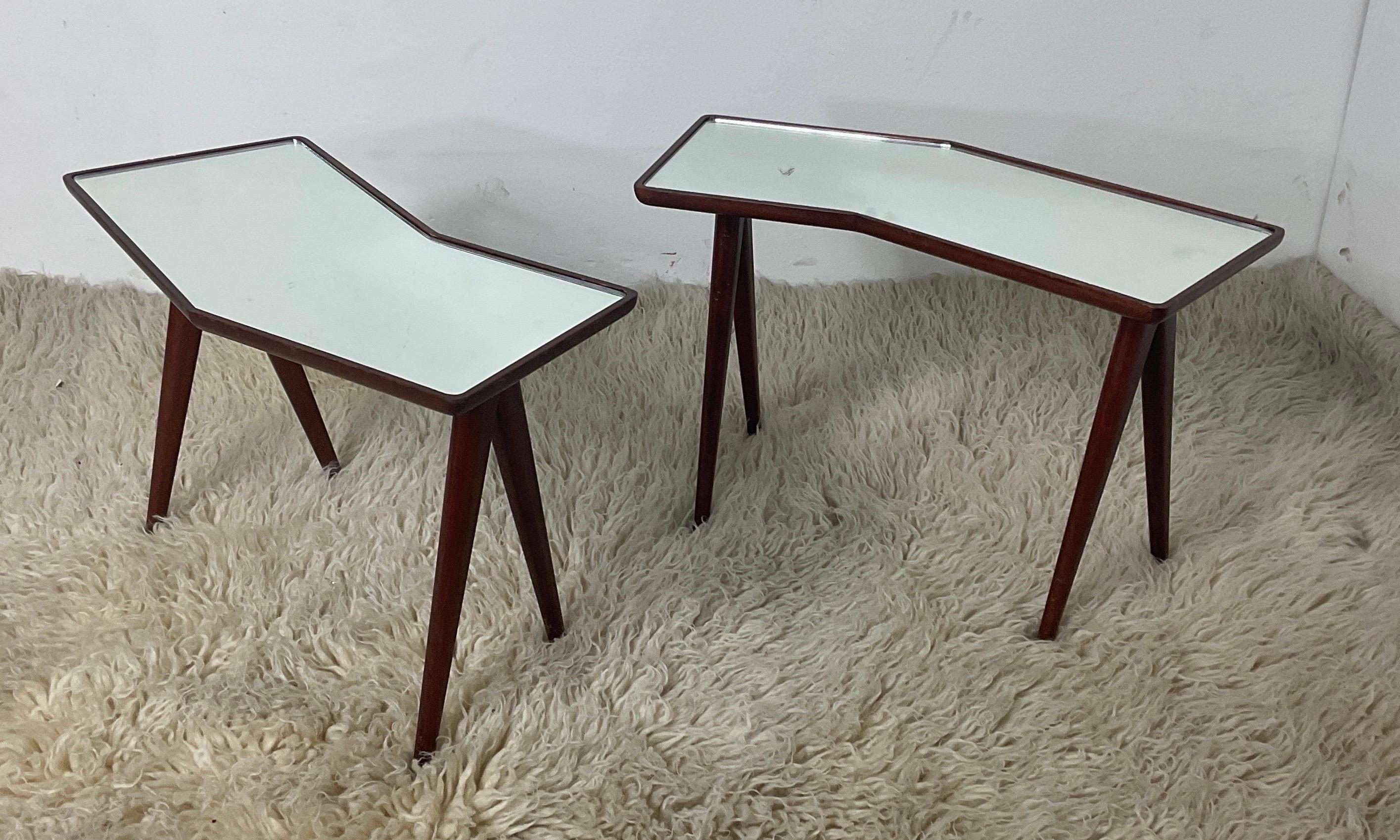 Pair of beautiful coffee tables with trapezoidal shape. The frame is made entirely of wood and the top is made entirely of mirrored glass. Design Gio Ponti. Production Fontana Arte. 1950s.

Width 61 cm Depth 25 cm Height 40 cm