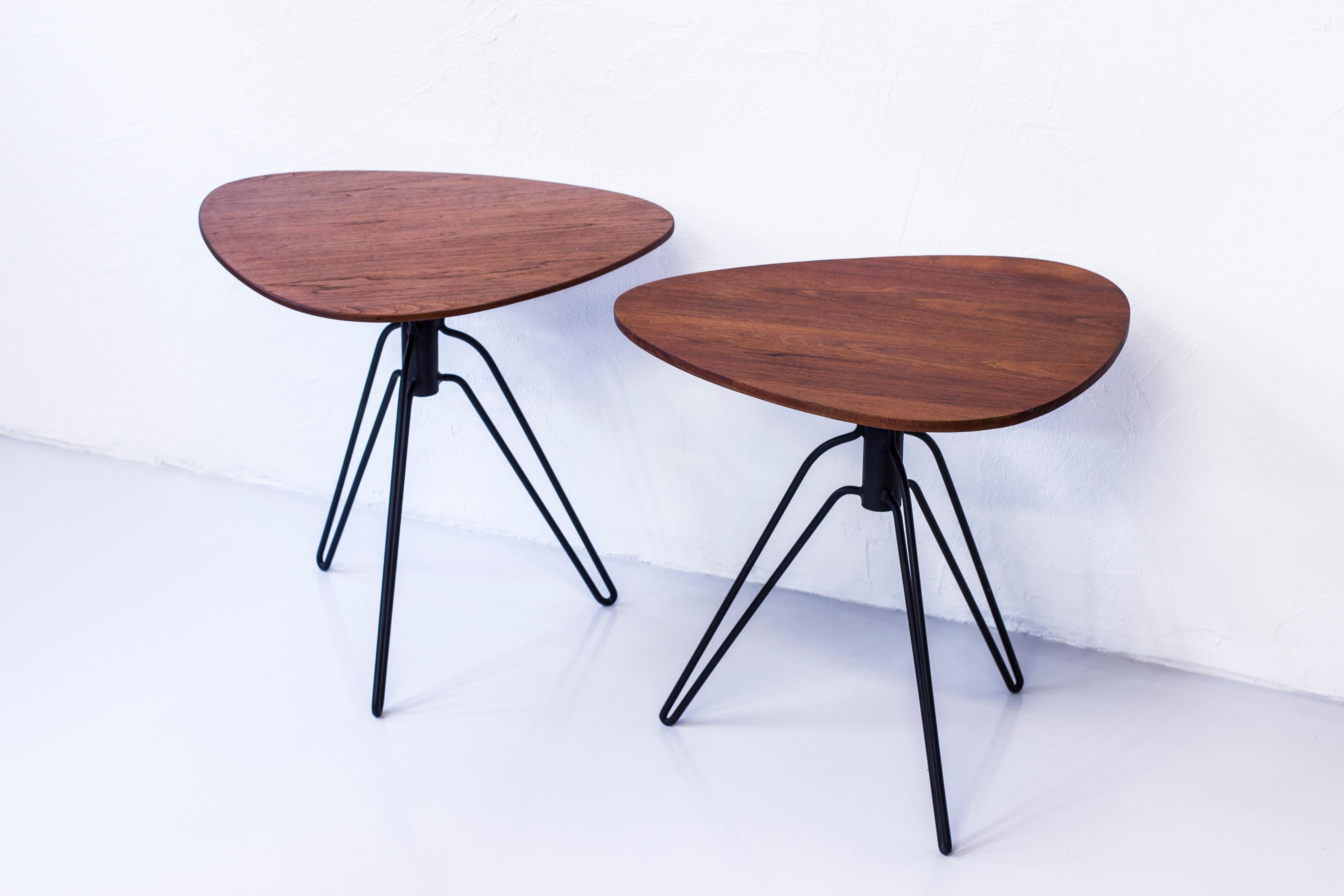 Pair of side tables designed by Hans Agne Jakobsson. Early, Pre-Marakryd production made in Åhus during the early 1950s. Made from solid teak and black lacquered metal. One table signed with original label. Very good condition with light signs of