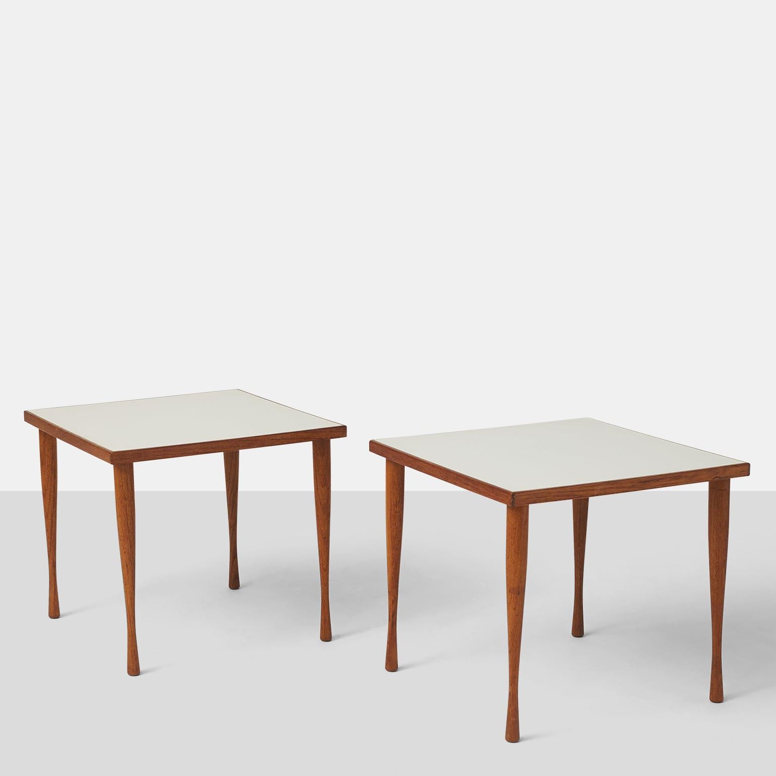 A pair of stacking side tables in walnut by Hans Anderson with inset white laminate top and shaped legs. 
Retains the original makers label.