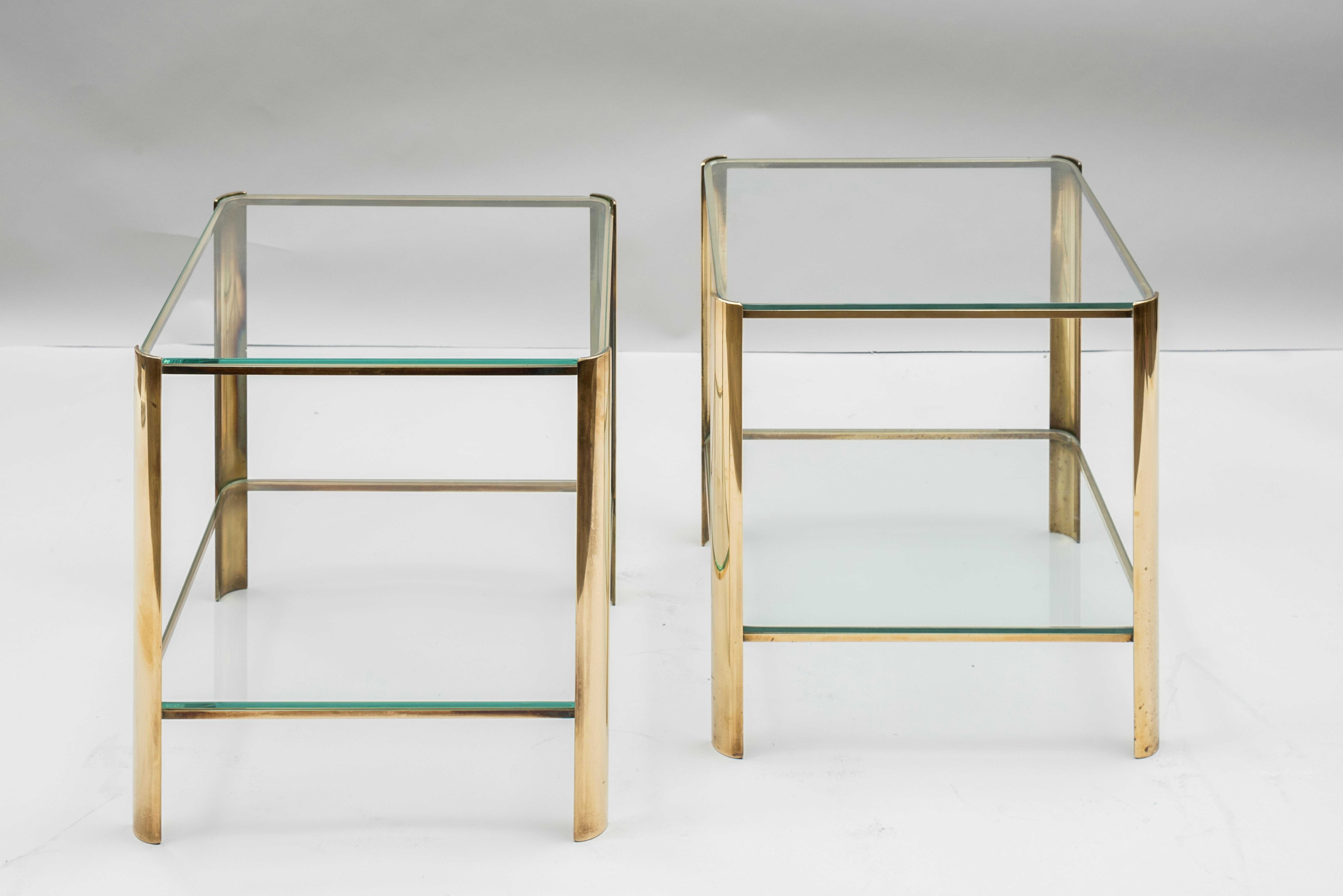 A pair of square tables, two tiers.
Glass tops 
Bronze feet
Designed by Jacques Quinet for Maison Malabert
France, 1970s

Measures: 
Height 44 cm (17.3 in.)
Width 40 cm (15.7 in.)
Depth 40 cm (15.7 in.).
  
